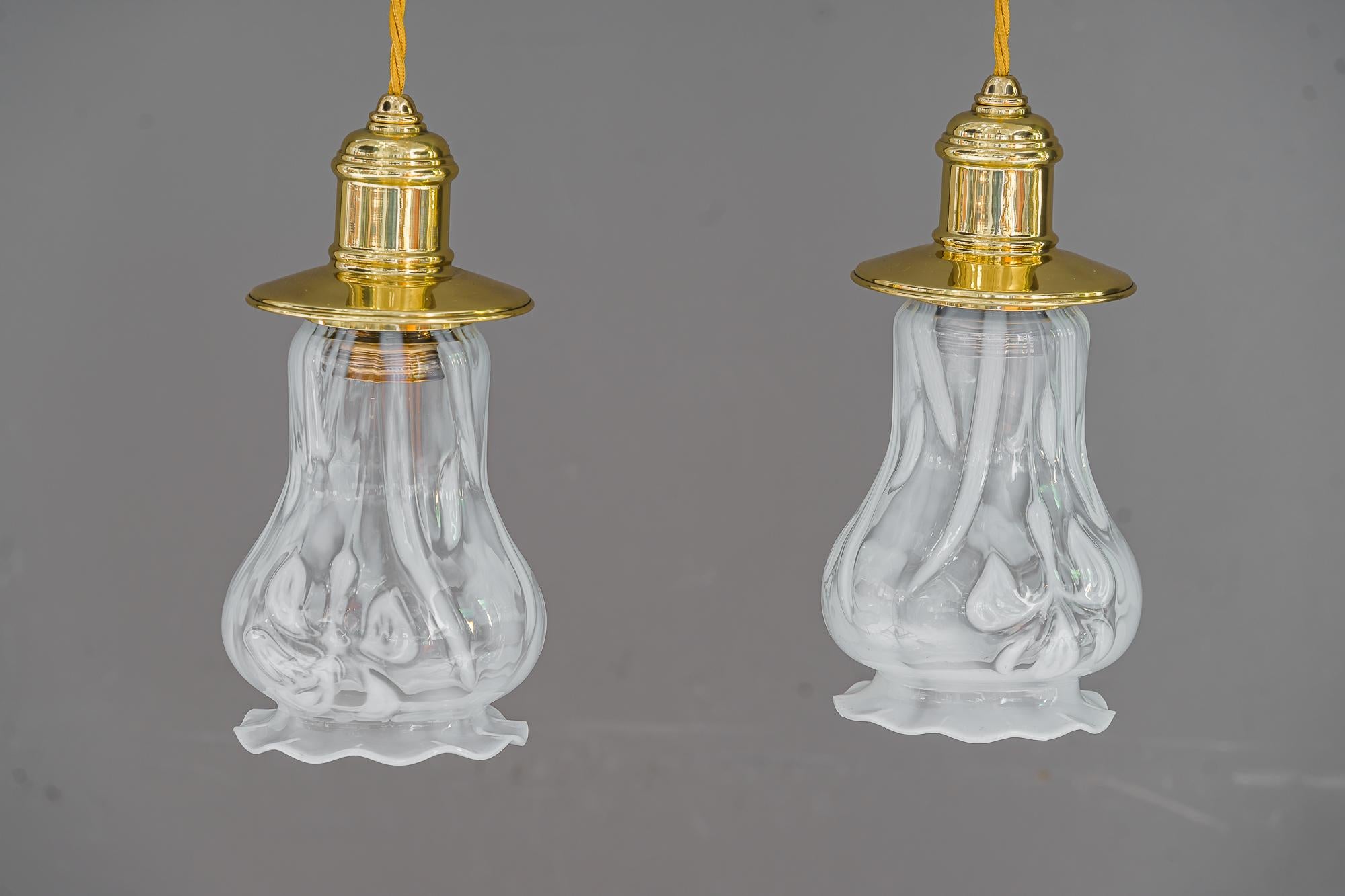 2 pendentifs Art Déco viennois vers 1920 avec abat-jour en verre opalin.
Laiton poli et émaillé au four.
Abat-jour en verre opalin d'origine.