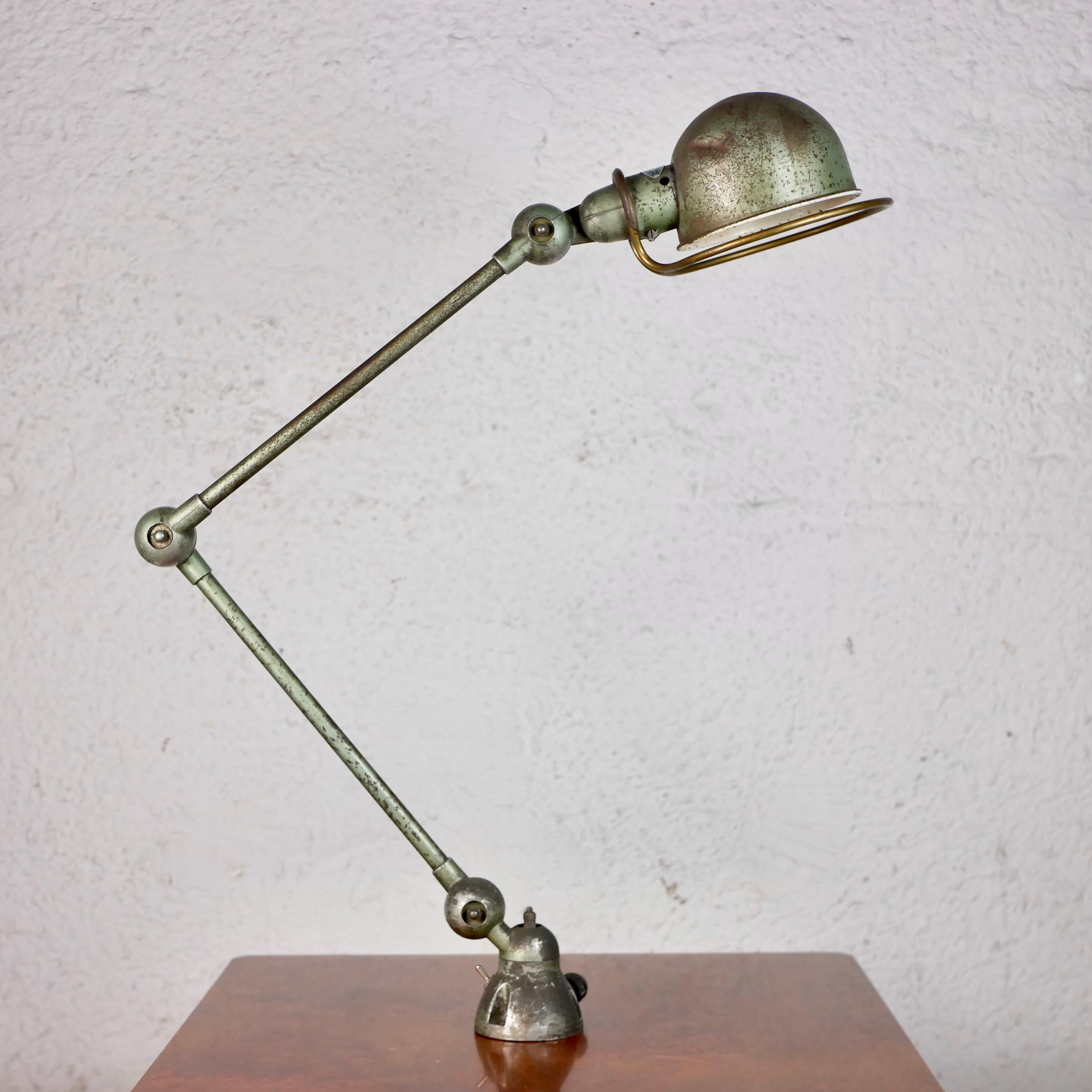 Famous Jieldé lamp in vespa green, designed by Jean-Louis Domecq (JLD) in the 1950s in Lyon, France. 
Very nice patina, high quality made, can be fixed to a desk or to the wall.
Very sturdy.
With its riveted label.
We particularly like the brass