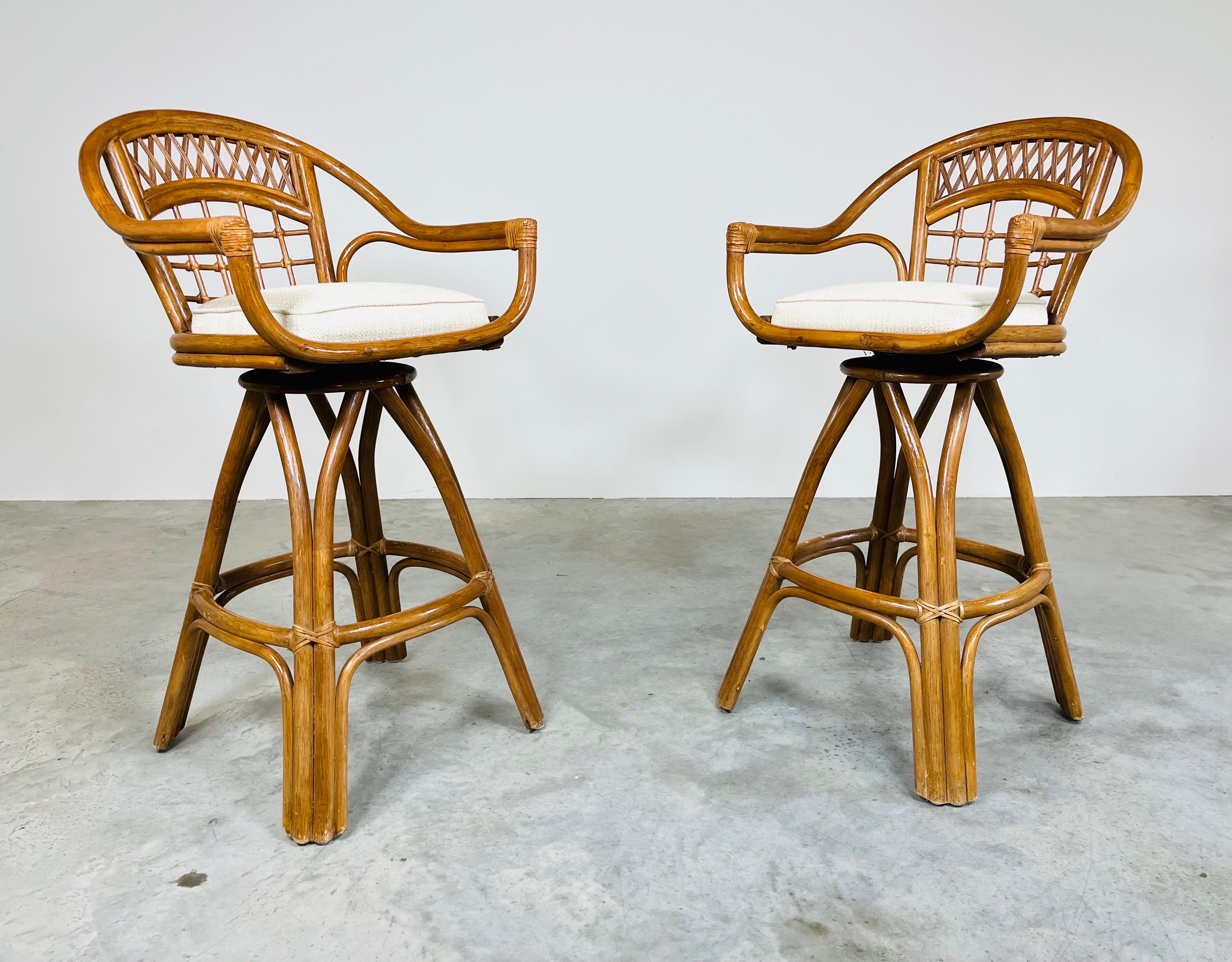 A beautiful pair of bamboo swivel barstools having leather joinery with new upholstered seats and new interior cushions. Swivel mechanics are smooth and silent with bamboo frames in excellent condition as well as the leather joinery. The seats are