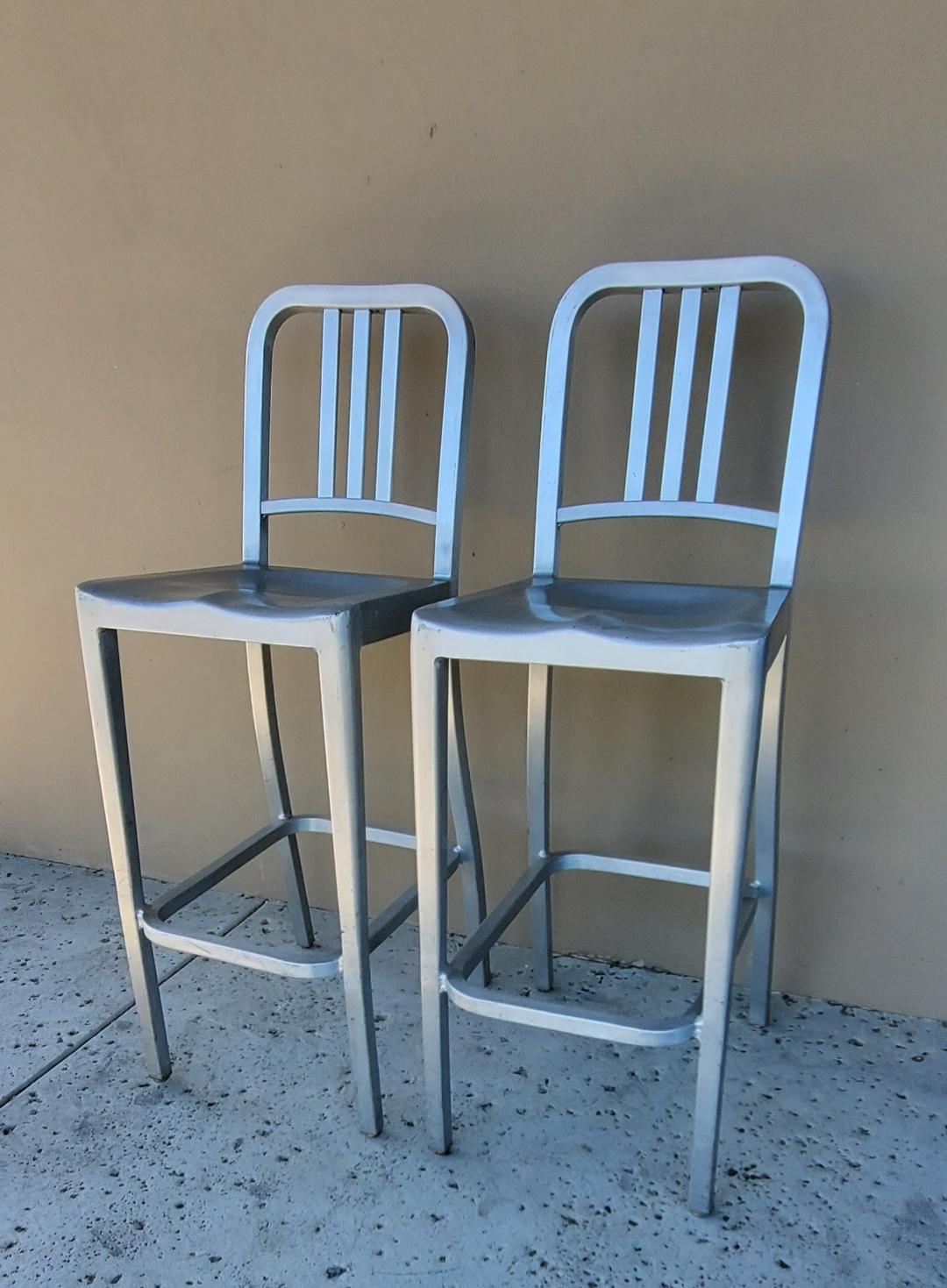 2 Tall Brushed Aluminum Indoor Outdoor EMECO Bar Stools, Labeled.

These Sturdy Brushed Aluminum EMECO Indoor Outdoor Bar Stools Are Very Comfortable With The Three Vertical Slat Back With Brushed Aluminum Footrest Ring.

Each Stool Has Some