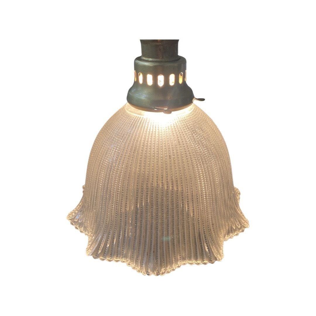Beautiful Mid-Century bell Holophane glass shade with brass hanging ceiling pendant light

A Holophane glass ceiling fixture is a type of lighting fixture that features a glass shade with a prismatic design that refracts light to create a soft,
