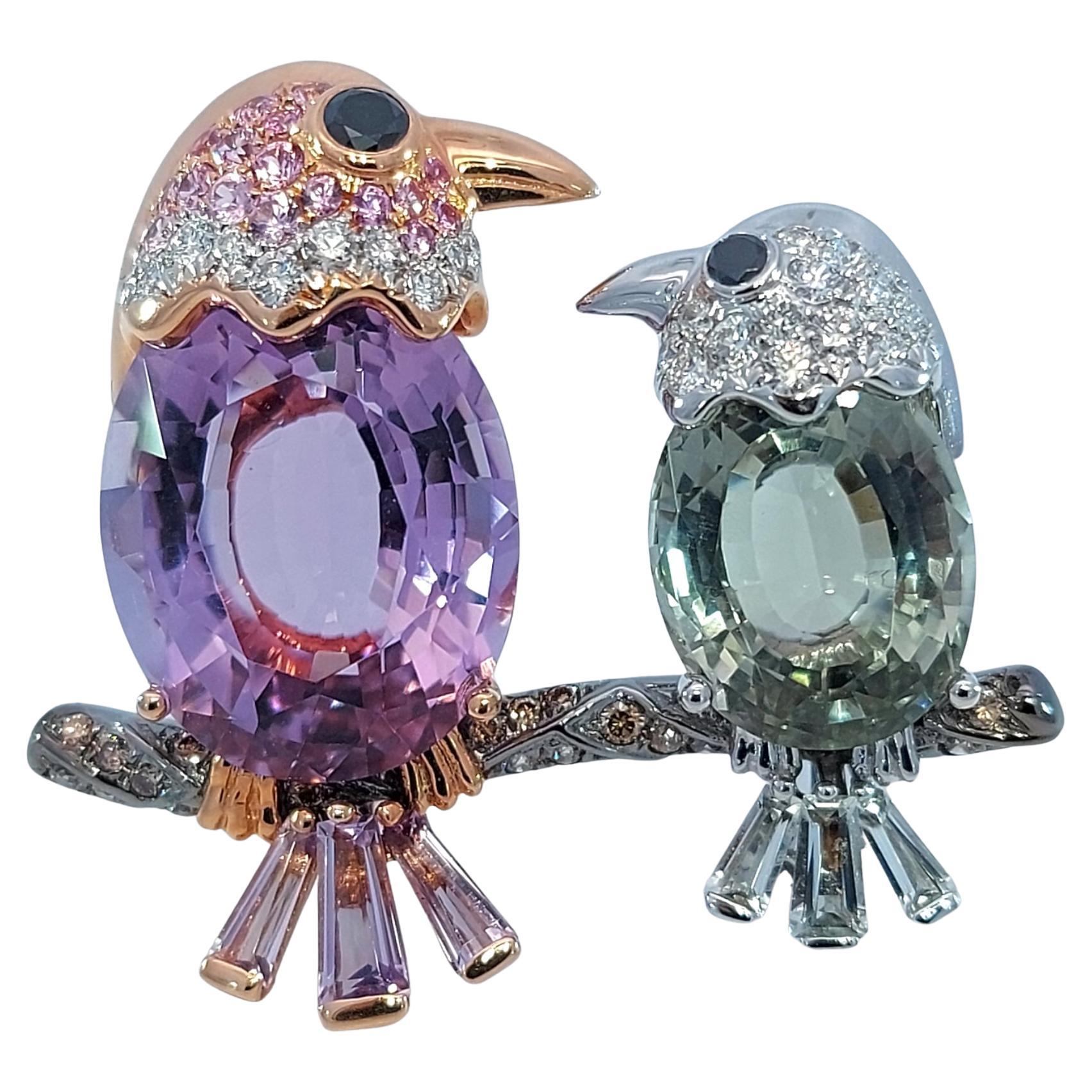 2 Birds on a Branch in 18kt Gold With 13.89ct. Semi Precious Stones, Diamonds, Pink Sapphire Brooch

Amethyst and tourmaline together 13.89 ct.

Diamonds:  White brilliant cut diamonds together 0.48 ct. Black diamonds together 0.10 ct. Cognac