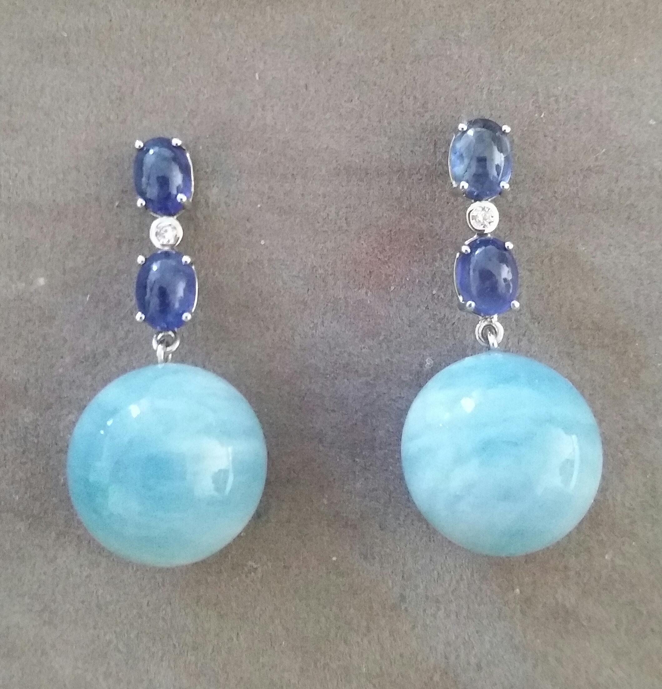 Elegant and completely handmade Earrings consisting of an upper part of 2 oval shape Blue Sapphire cabs of 4 mm x 5 mm set together in 14 Kt white gold with a  small diamond in the middle, at the bottom 2 Natural Aquamarine Plain Round Beads