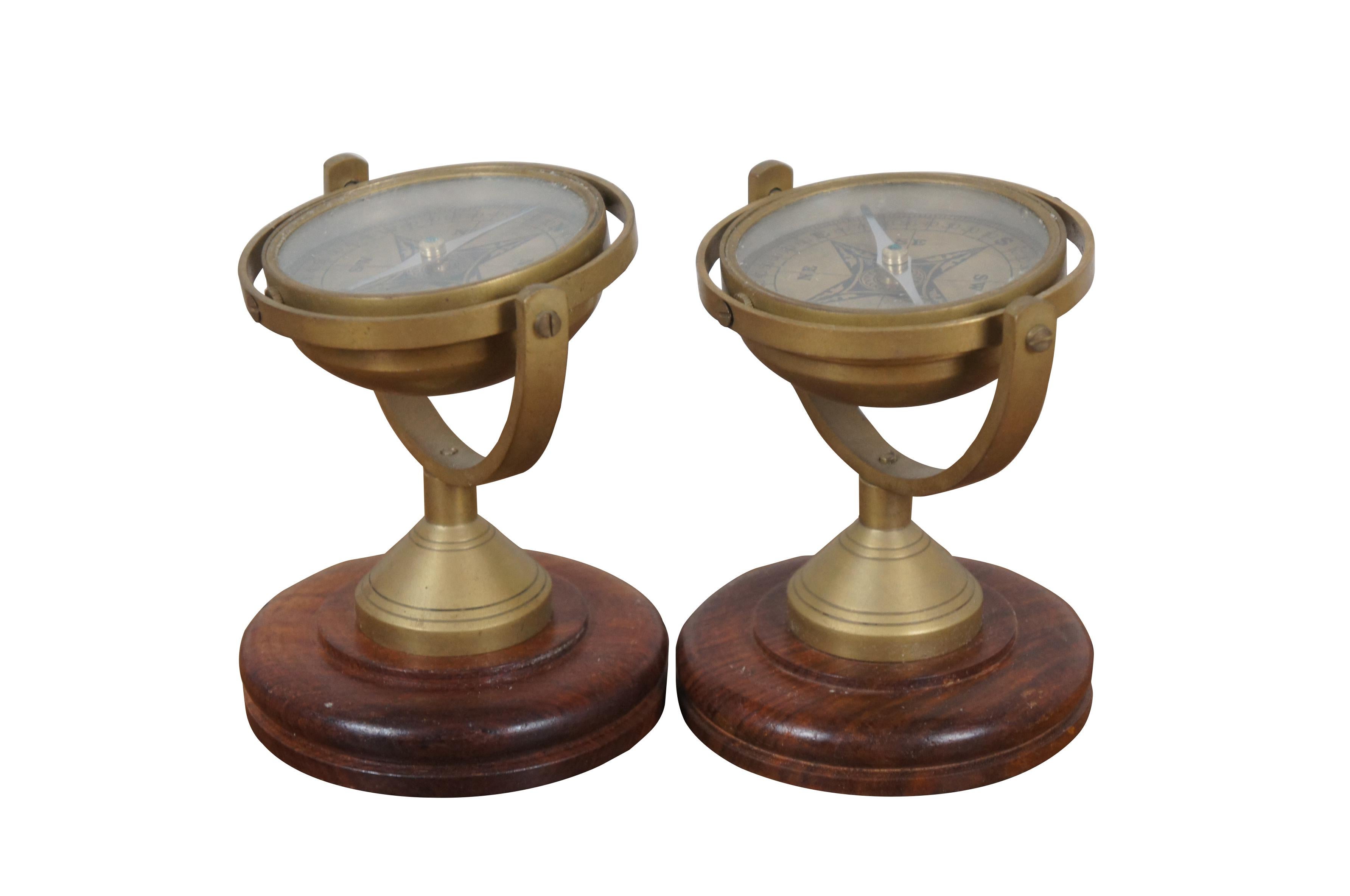 Pair of late 20th century free standing brass swiveling / gimbal nautical compasses on wood pedestal stands.

Dimensions:
4