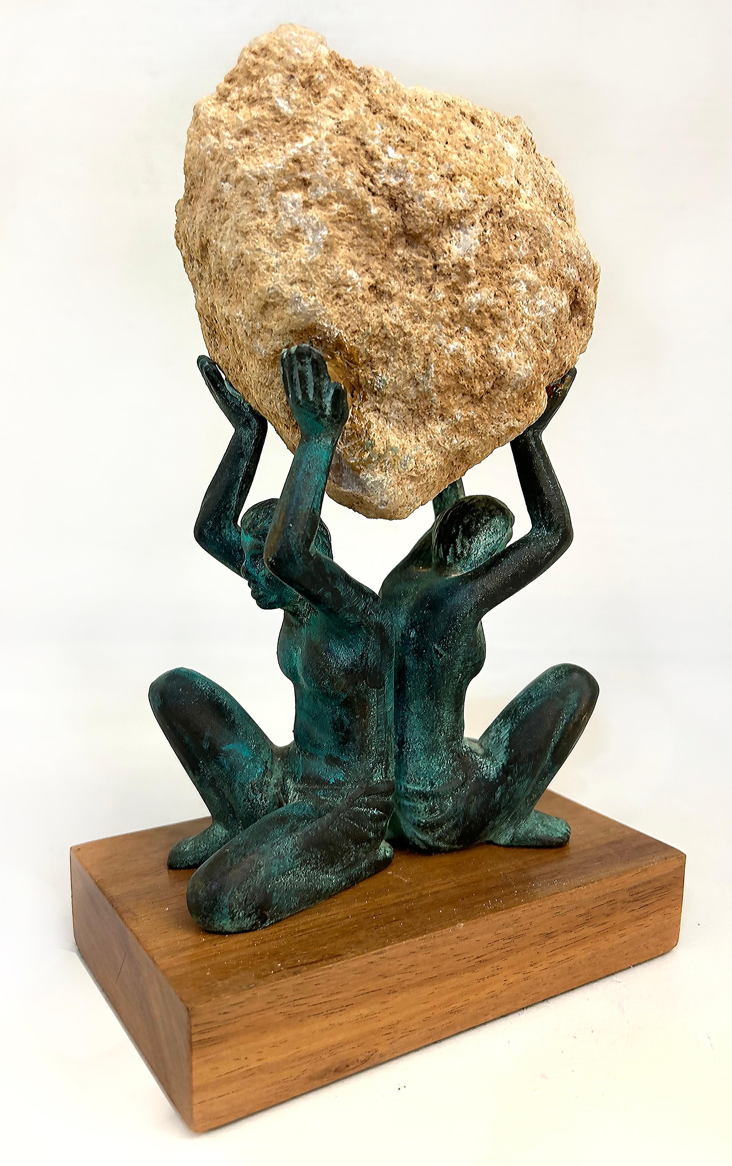 Bronze Figurative Sculpture of Two Figures Supporting a Natural Quartz Specimen

Offered for sale is a patinated bronze figurative sculpture of two figures supporting a natural quartz geode specimen. The figures are presented upon a wood plinth.