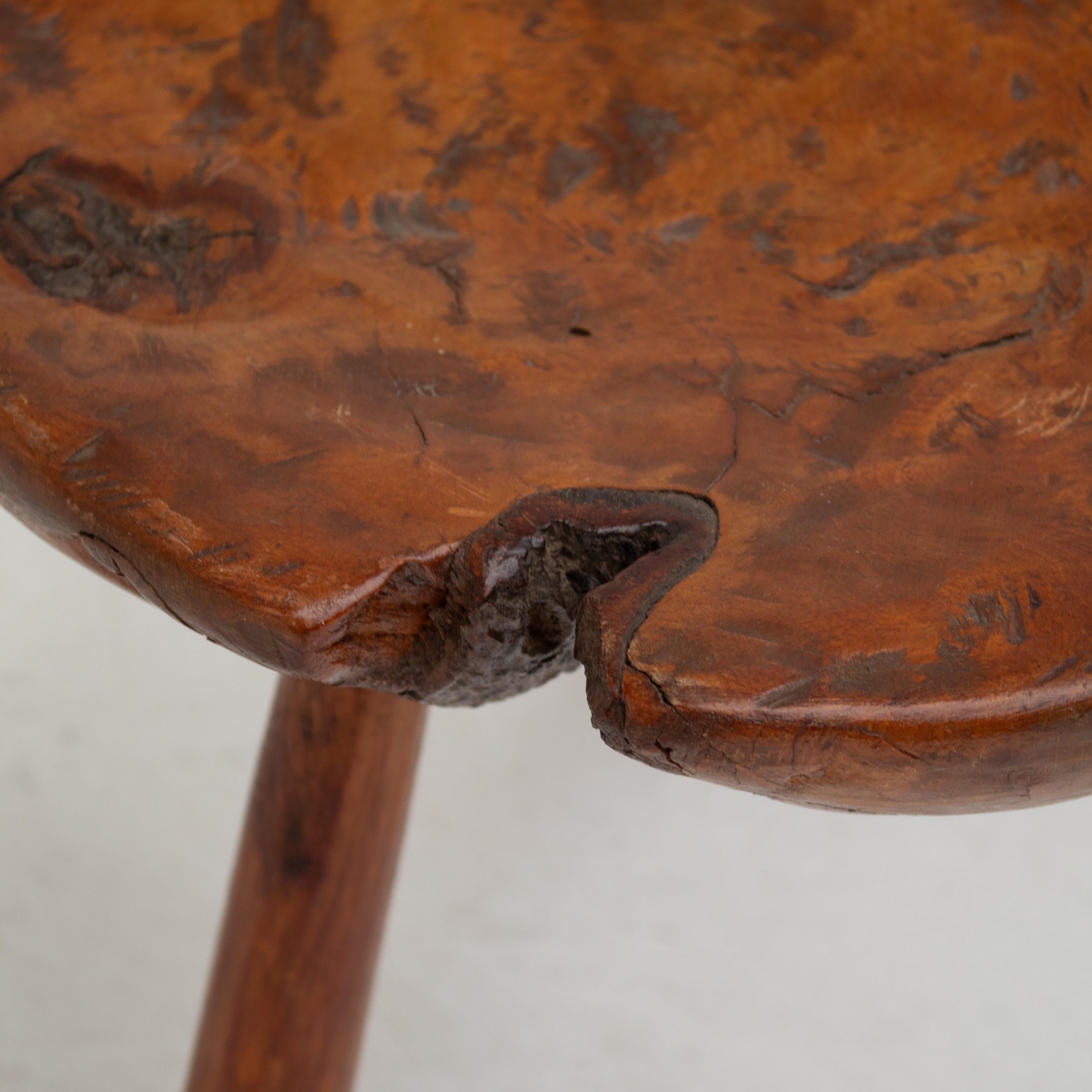 Diese brutalistischen Vintage-Hocker haben einen starken, rustikalen Charakter. Jeder Sitz ist aus einem massiven Holzblock geschnitzt und steht auf drei schrägen Beinen. Die organischen Formen, die sichtbare Maserung und die natürlichen Risse