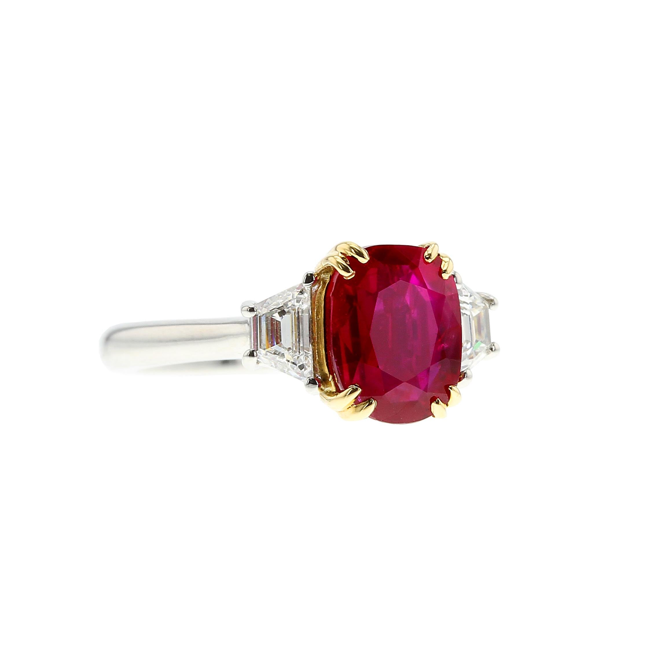 A classic three-stone ring set with a natural, no-heat Burmese ruby weighing over 2.50 carats, further accented with two trapezoid-shaped diamonds weighing a total of 0.42 cts. of an estimated color-clarity of F-VS2, set in Platinum and 18k Yellow