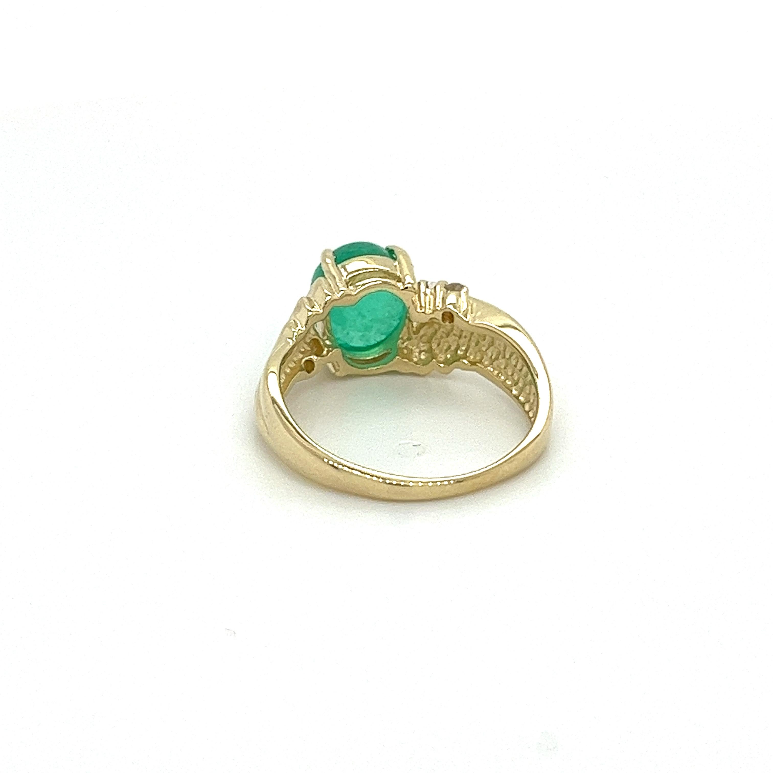 14K solid yellow gold ring, featuring a 2.0 carat cabochon cut natural emerald as the center stone. The textured ring showcases a 4.5mm width band with a textured shank and sharp geometric pattern. A mesmerizing emerald, with its lush green color