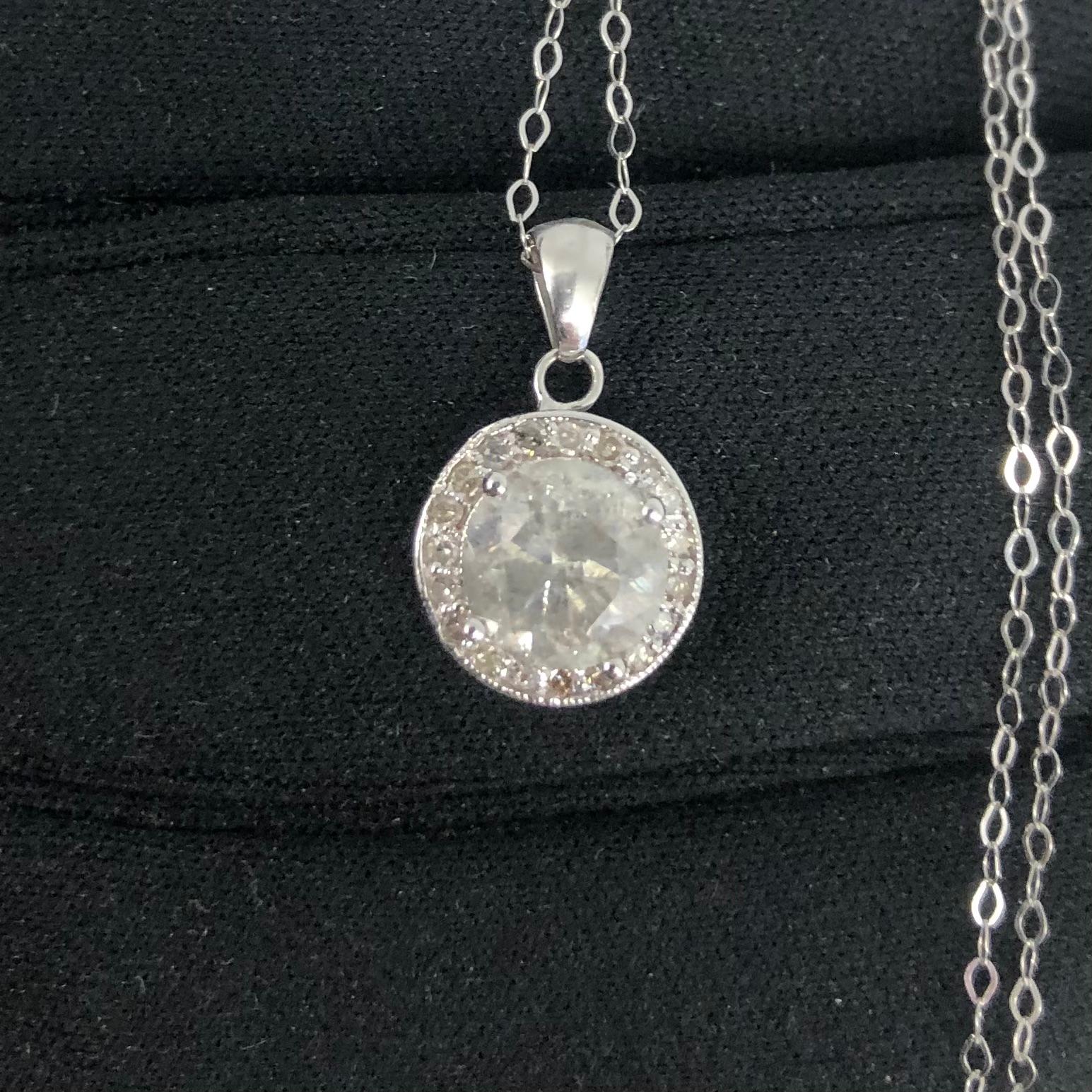 Opulent approx. 1.76 carat solitaire round diamond pendant in 14k white gold with necklace chain. A center brilliant round diamond weighing approx. 1.76 carats (natural earth-mined diamond enhanced) surrounded by approx. 1/3 carats of halo side