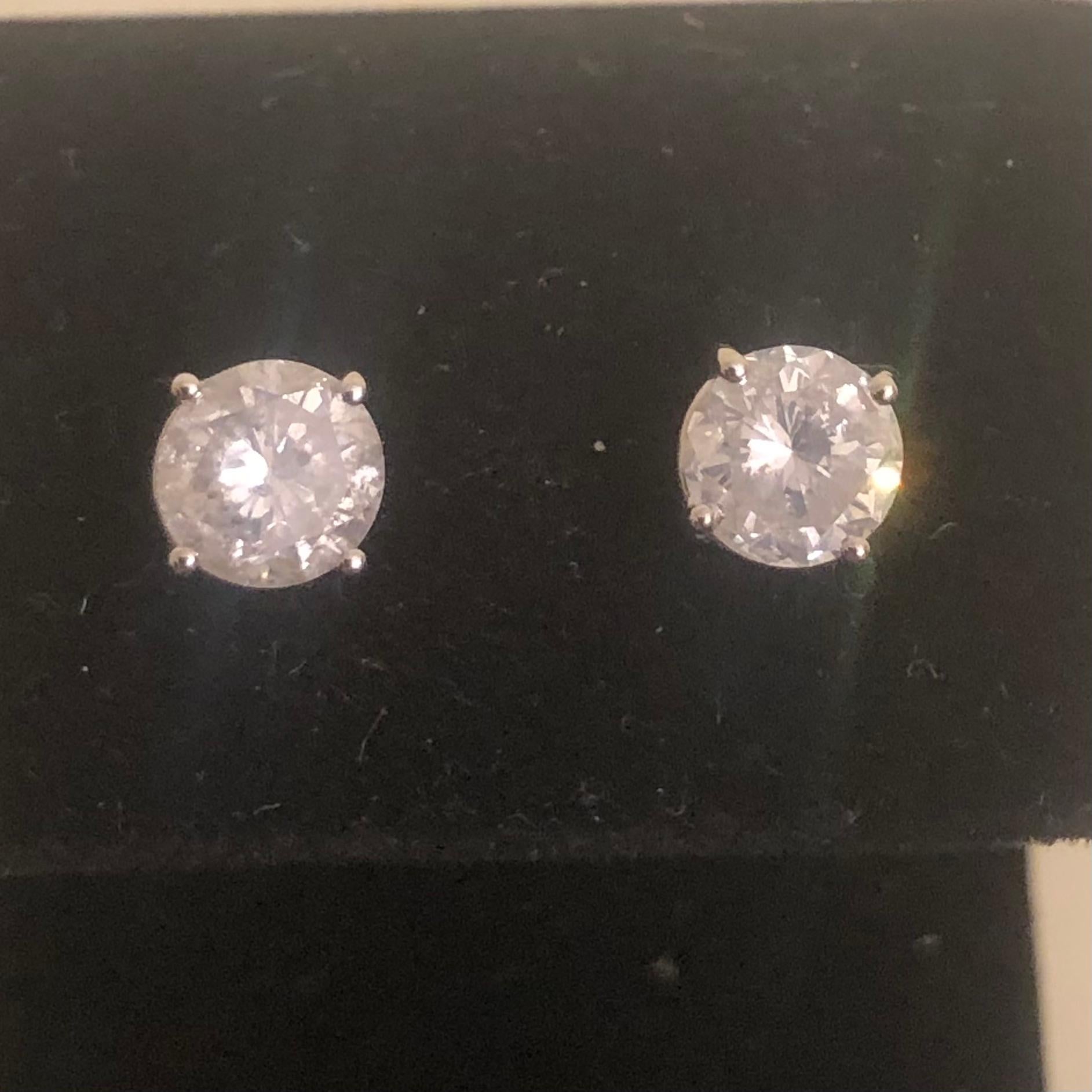 Stunning 2 Carat Brilliant Round Solitaire Diamond Stud Earrings in 14K White Gold. These natural diamond studs are certified with an appraisal report value of $8,850.00.

A large center 1 carat plus solitaire diamond (size of an engagement ring) is