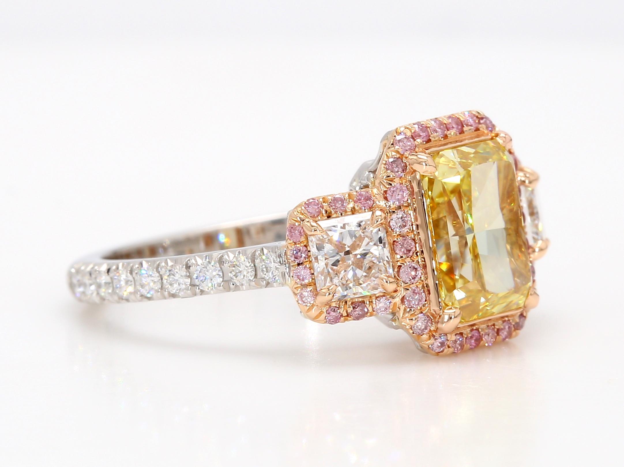 A breathtaking Three-Stones Engagement Ring featuring a 2-carat Fancy Intense Yellow Radiant cut diamond, GIA certified as VS2 in clarity, flanked by two Radiant cut diamonds with a total weight of 0.64 carats and E-F color. The classic design