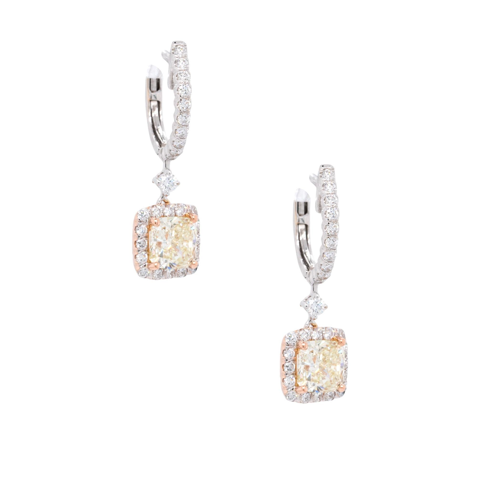 These earrings are made of 18k white gold and feature two natural cushion-cut diamonds, each weighing 1.00 carat. One diamond has an S/T color grade and VS clarity, while the other has an M color grade and VS2 clarity. The earrings also have