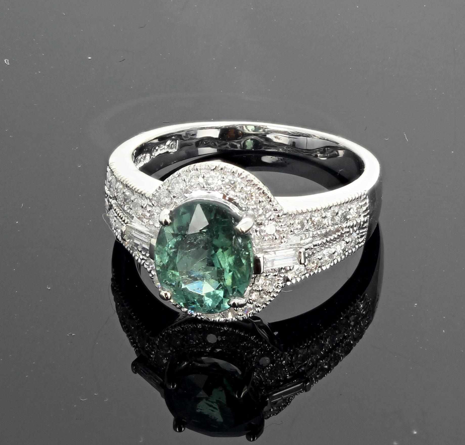 Glittering brilliant oval 9 mm x 7 mm green Tourmaline set in a 14Kt White Gold ring enhanced with sparkling white Diamonds (0.50 carats).  This beautiful green Tourmaline ring is sizable 7 (we size for free) and would make a beautiful engagement