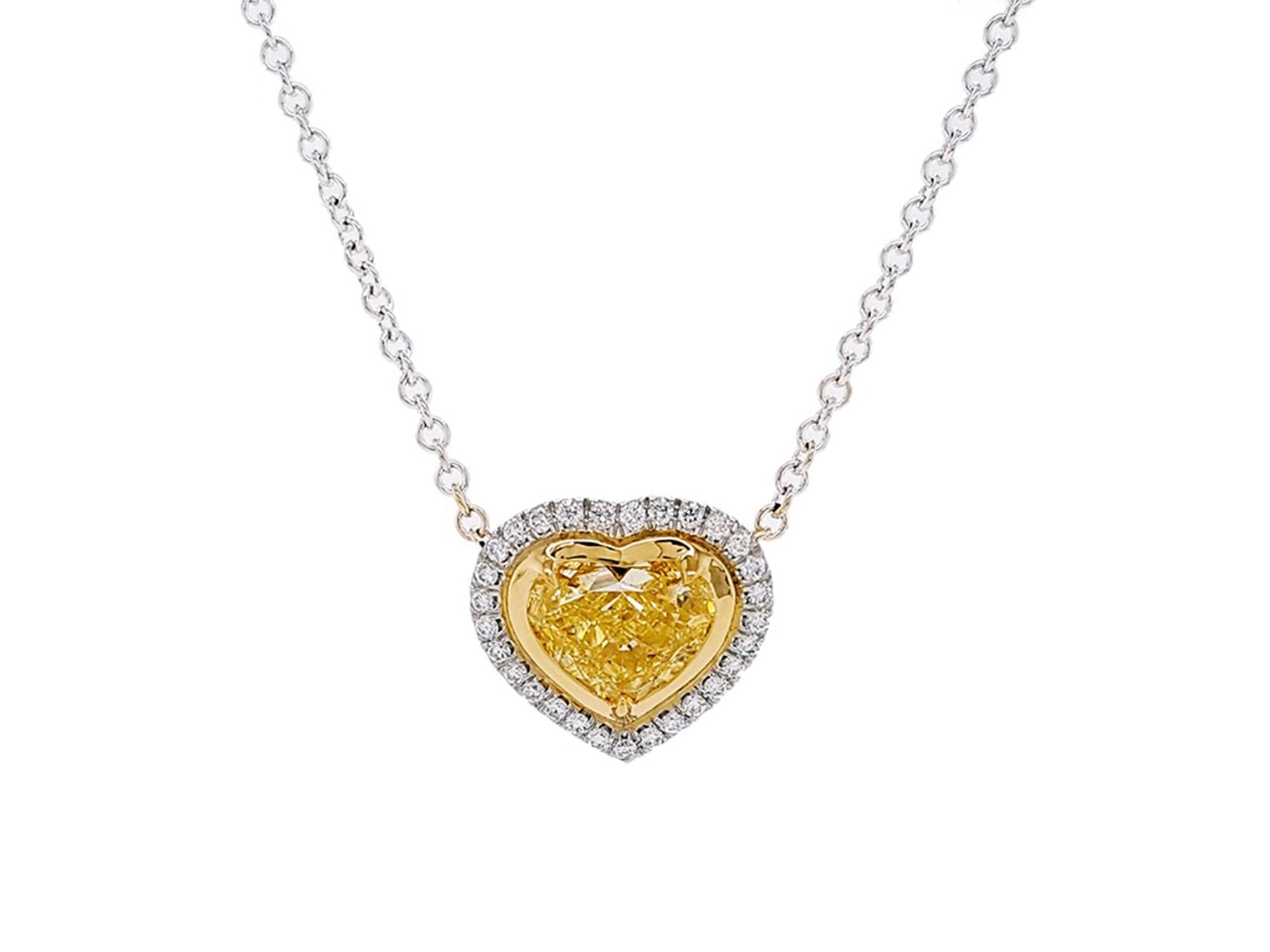 Introducing a breathtaking Halo Pendant Necklace boasting a 2.01 Carat Heart-shaped Fancy Intense Yellow Diamond at its core, GIA certified with VS2 clarity. This timeless design accentuates the elegance of the central stone, complemented by 29
