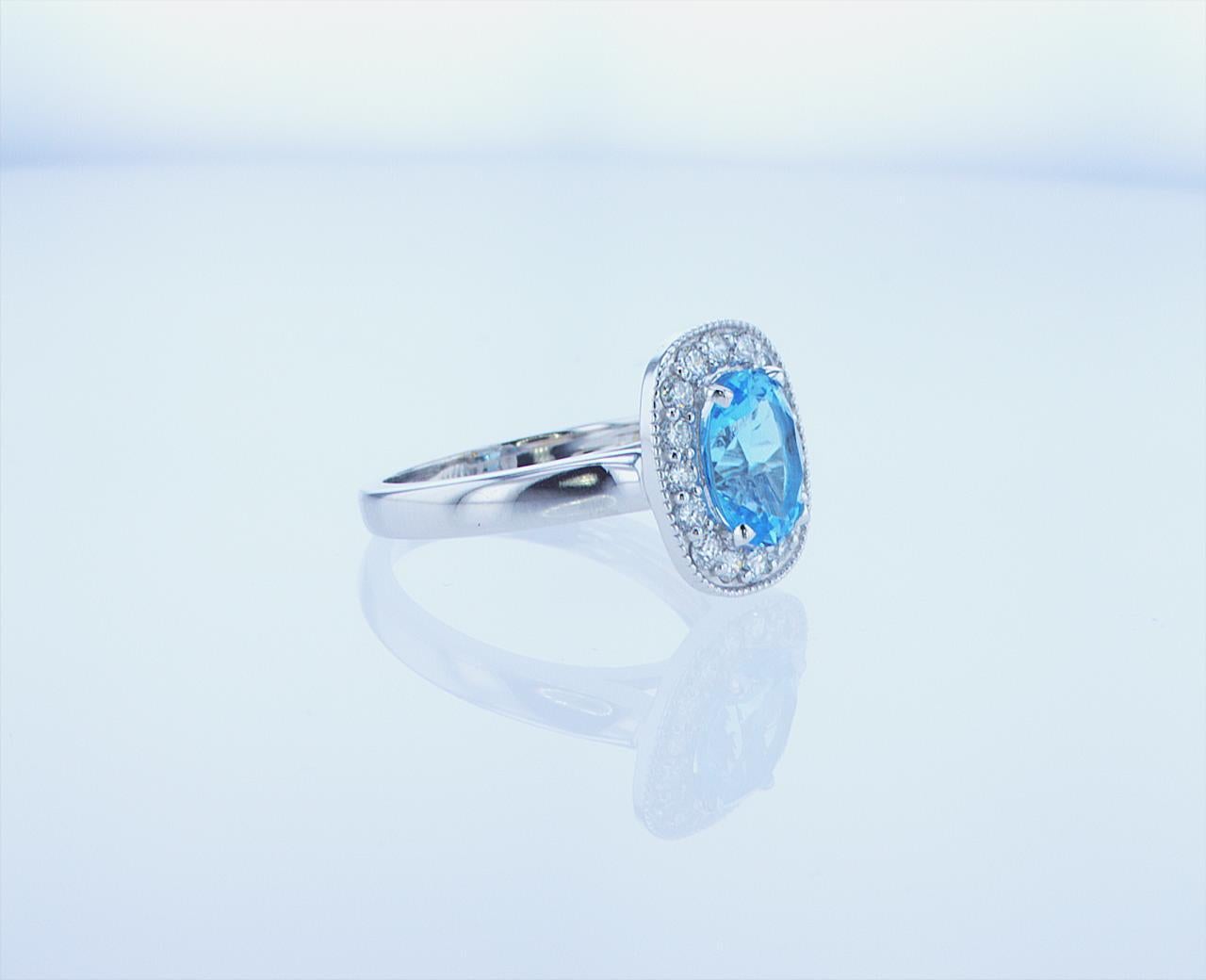 Modern 2 Carat Oval Blue Topaz Ring with Half Carat of Accent Diamonds For Sale