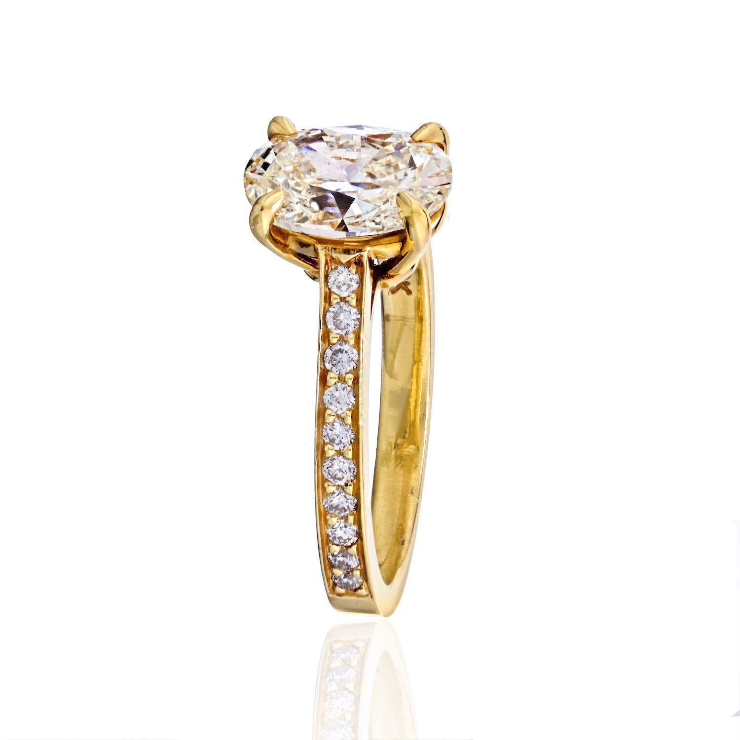 This oval cut diamond solitaire is set in a handmade four-prong 18K Yellow Gold mounting with a diamond pavé band. Our engagement rings are hand-crafted in New York, custom tailored to any desired specification and utilizing GIA-certified diamonds.