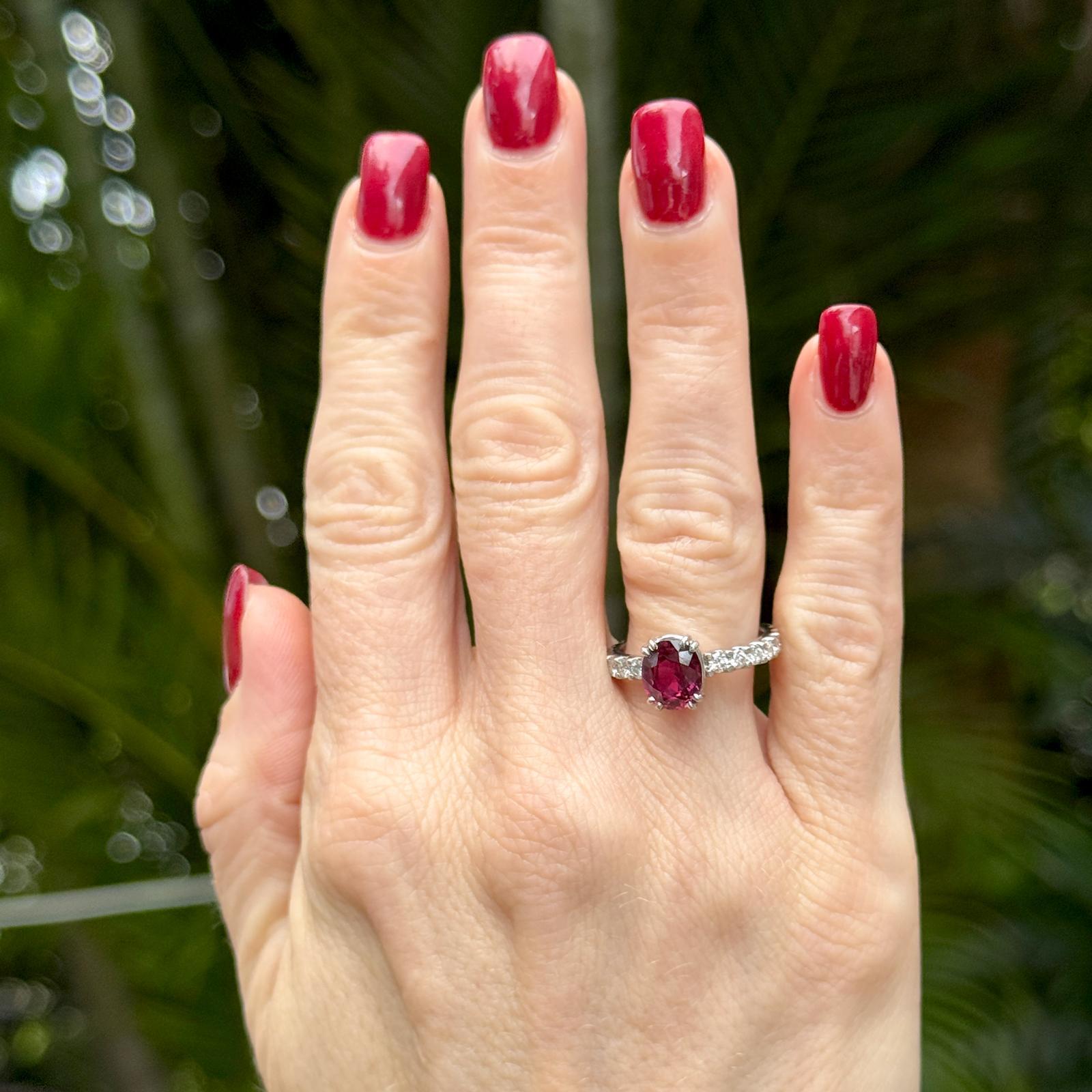 Este exquisito anillo de platino tiene un rubí ovalado de aproximadamente 2,00 quilates como vibrante pieza central. Catorce diamantes redondos talla brillante, con un total de 0,60 quilates de color G-H y claridad SI1, están elegantemente