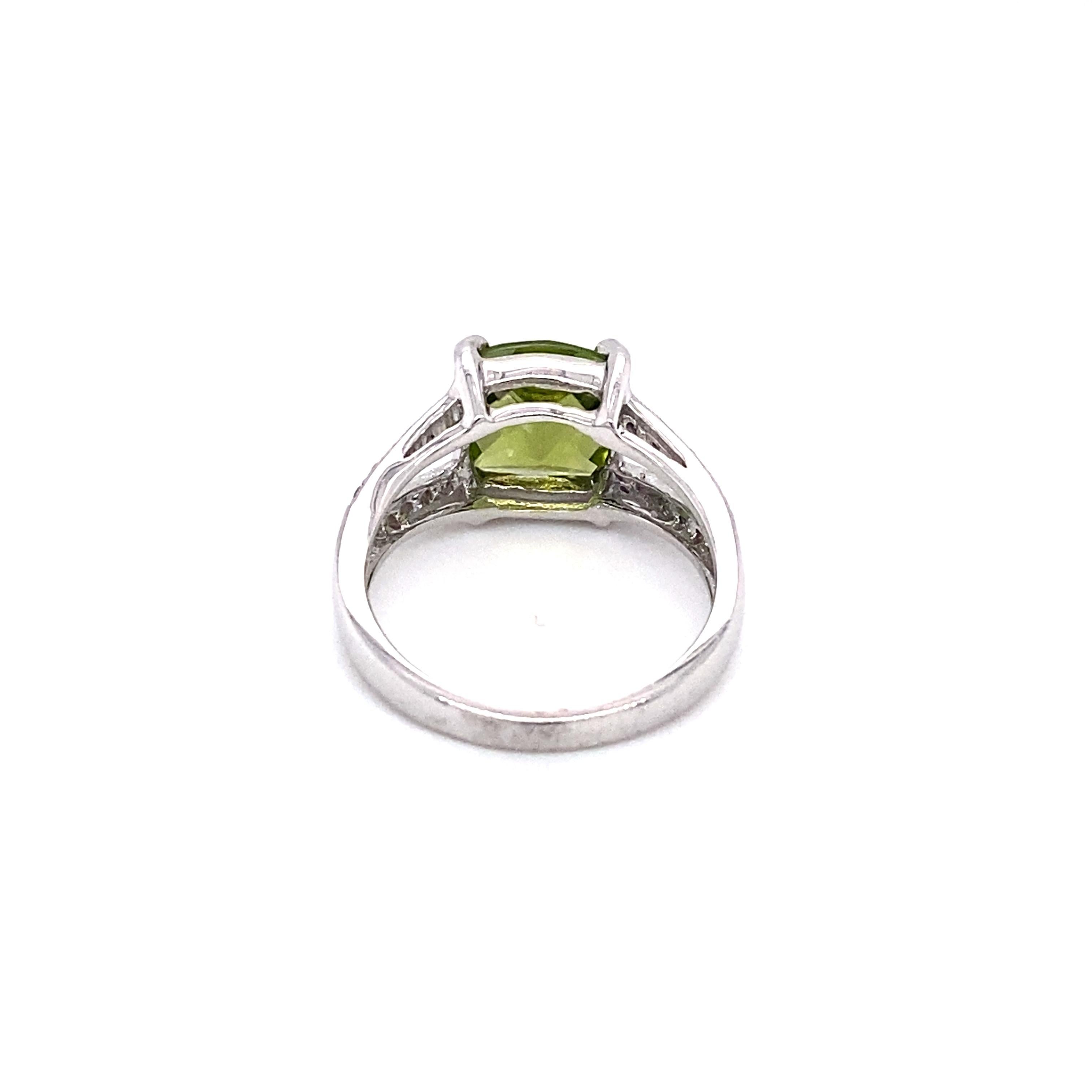 Circa: 1990s
Metal Type: 14K white gold
Weight: 3.9g
Size: US 6, resizable

Diamond Details:

Carat: 0.20 carat total weight
Shape: Round brilliant
Color: G
Clarity: VS

Peridot Details:

Carat: Approximately 2.0 carats
Shape: Checkerboard faceted