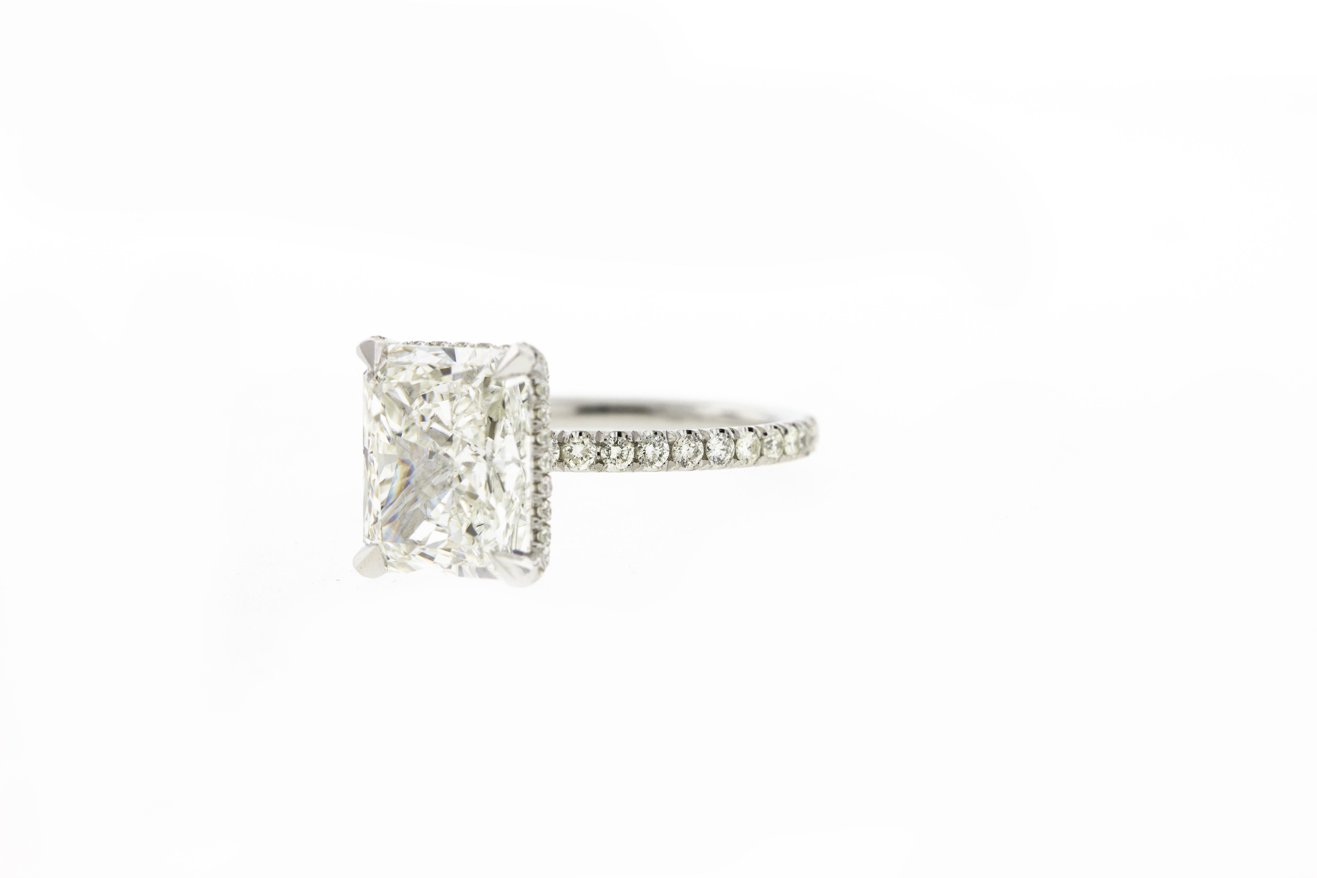 This GIA certified 2 carat radiant cut diamond is mounted on an 18K White Gold setting. The ring features matching diamonds on the legs (underside) of the rings basket and diamond pave on the shank.