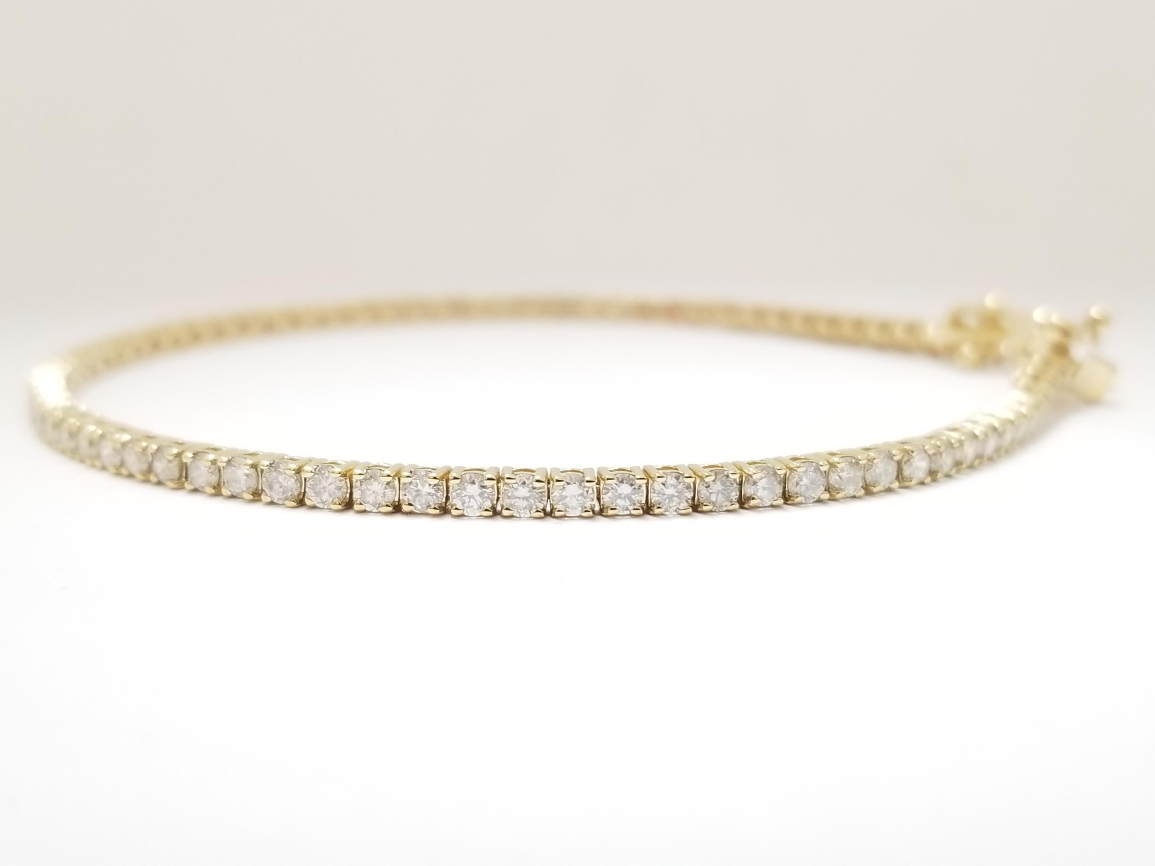 A quality tennis bracelet, natural round-brilliant cut diamonds. 2.05 t.c.w., . set on 14k yellow gold. each stone is set in a classic four-prong style for maximum light brilliance. double-latch safety. Push-button clasp. 7 inch length.  Average