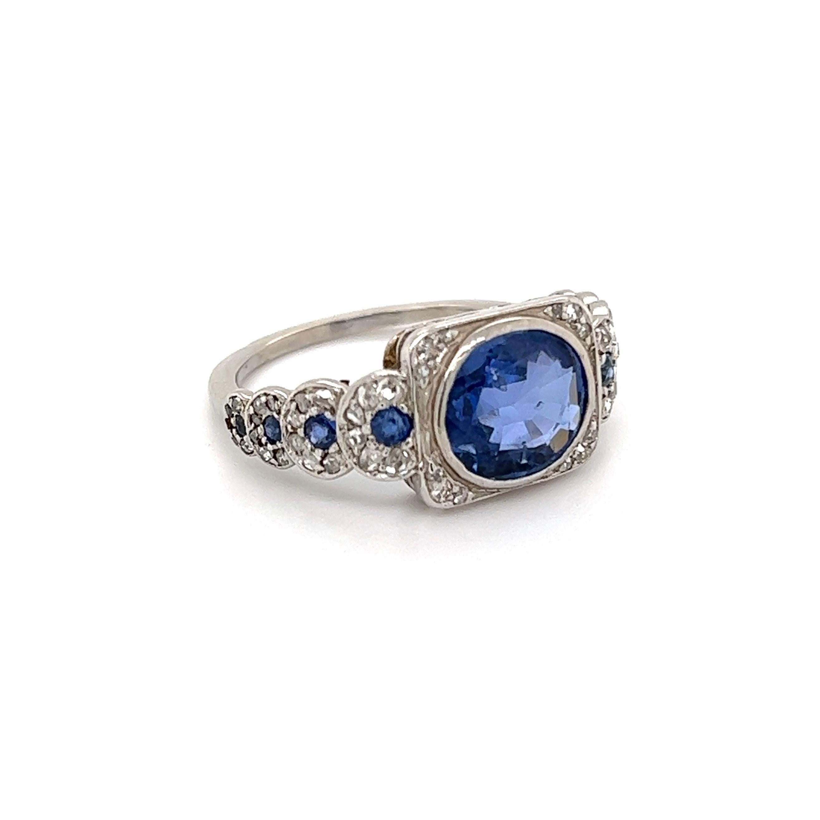 Simply Beautiful! Elegant and finely detailed Sapphire and Diamond Art Deco Revival Cocktail Ring. Center Hand set with a securely nestled 2 Carat Oval Sapphire accented by Diamonds, weighing approx. 0.65 total Carat weight and around the Diamonds,