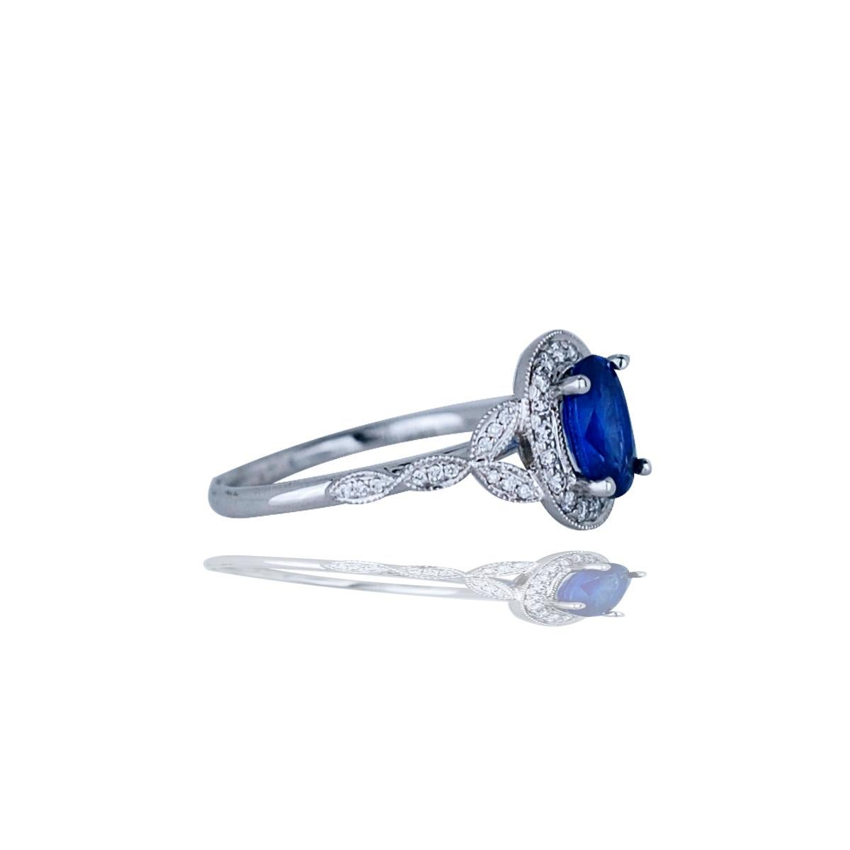This sapphire has a gorgeous blue sapphire with an even blue color tone.  The center stone has a rich cobalt blue color and SI clarity.  The center stone is complimented by over .30 carats of white G-H SI.  The ring is crafted from 14k and has