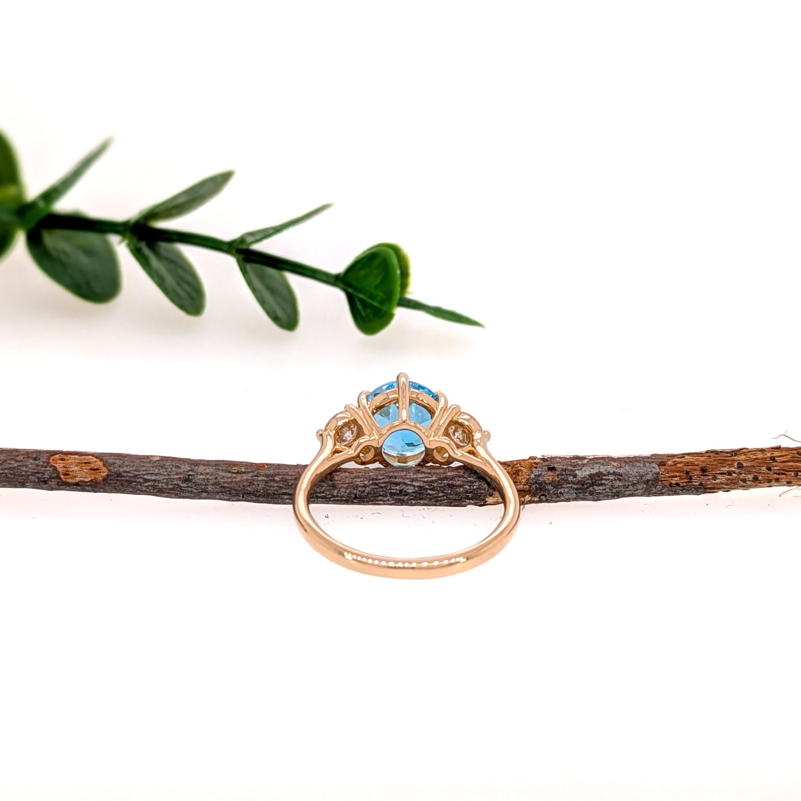 Fabriquée en or massif 14K, cette exquise bague à trois pierres met en valeur une brillante topaze bleue suisse de 2,1 carats, flanquée de diamants naturels étincelants, issus de sources éthiques et de mines terrestres. Une pièce luxueuse qui allie