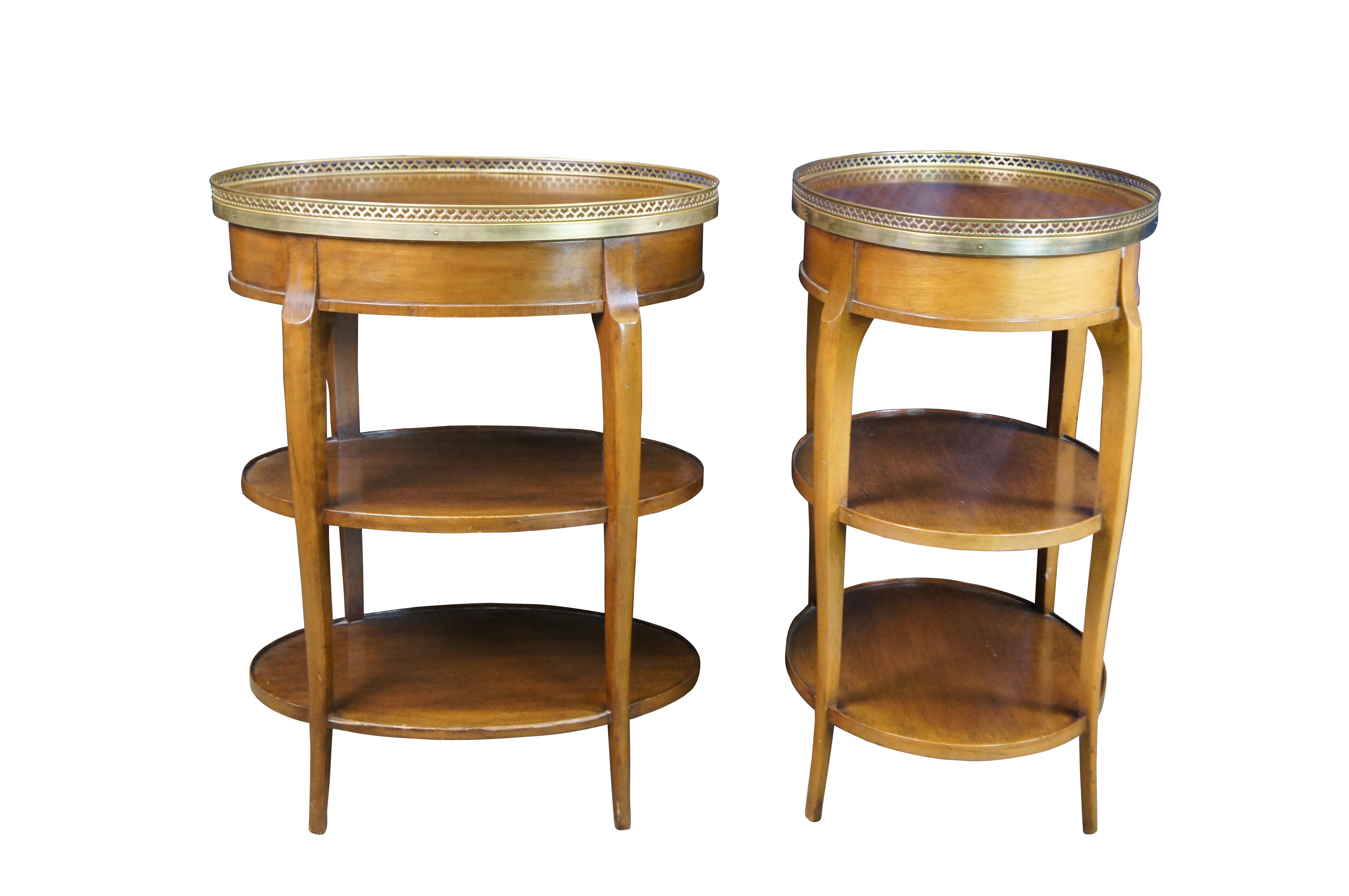 Two mid to early 20th century Cassard Romano French louis xvi style tiered side tables.  Made of walnut featuring oval form with one drawer, three tiers, and reticulated / pierced brass heart gallery.

Cassard Romano circa 1930s-1950s, were