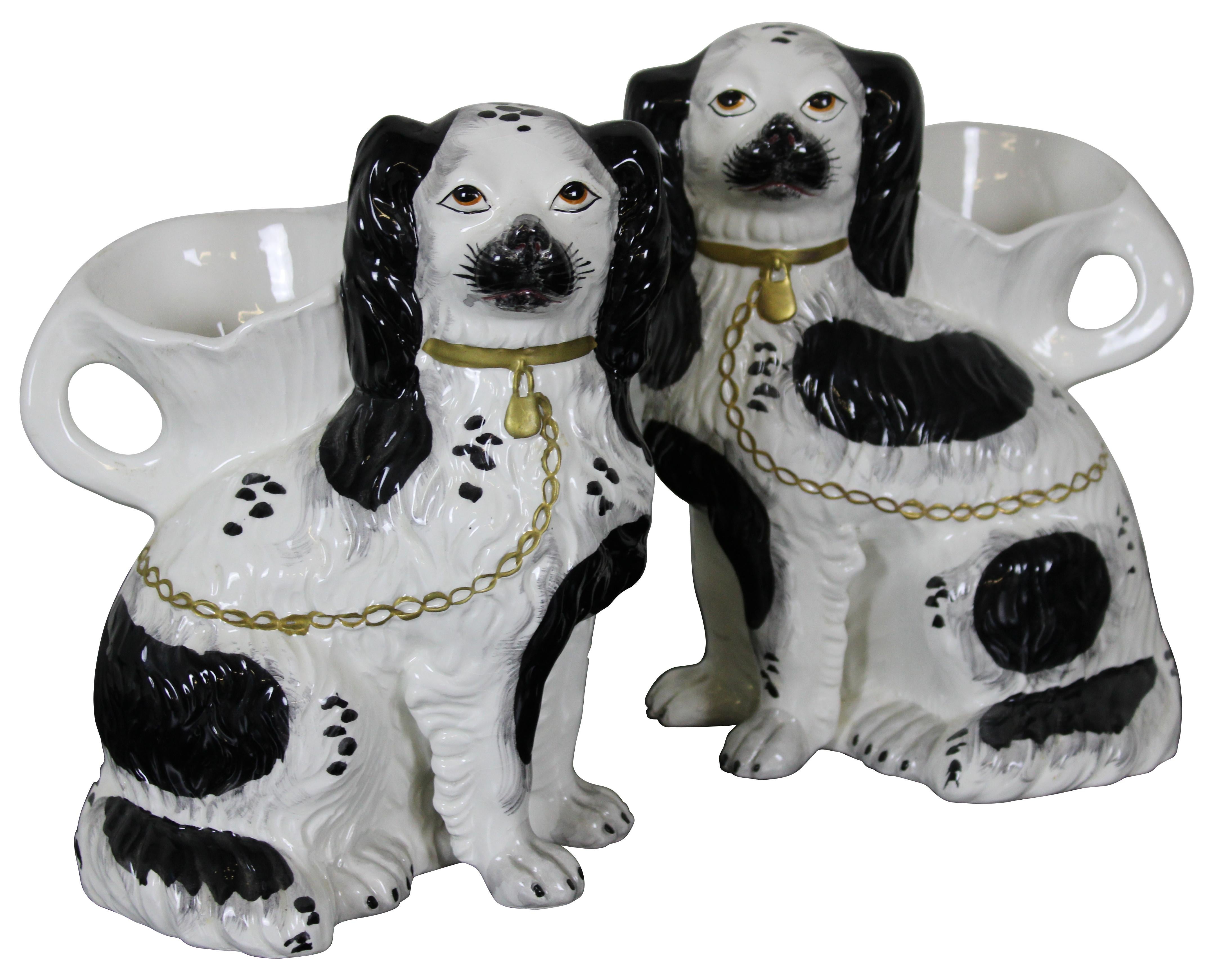 Pair of reproduction Staffordshire style porcelain mantel vases by Chelsea House, Port Royal, in the shape of black and white King Charles Spaniels with gold chain leashes.
   