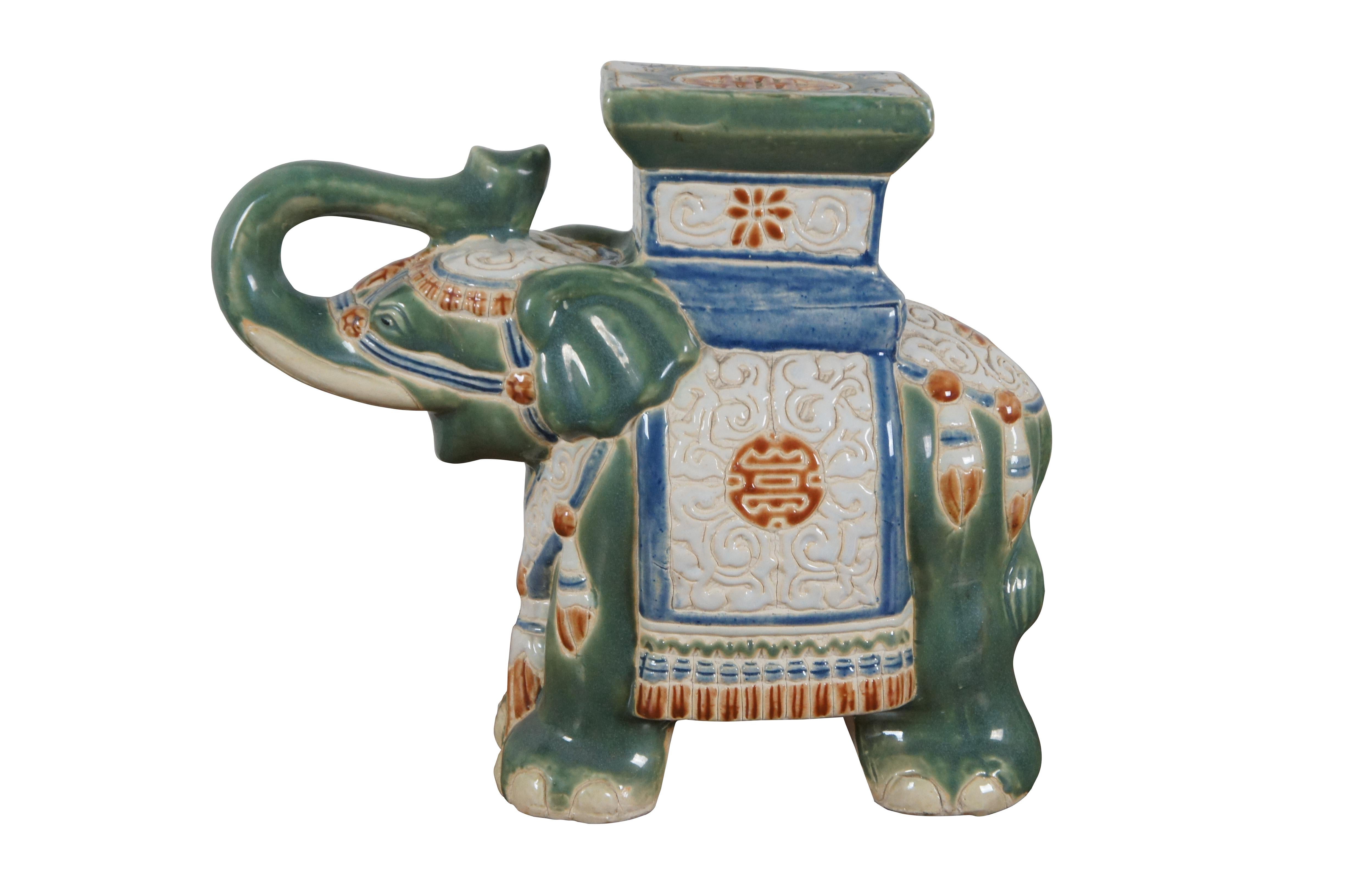 Pair of vintage majolica style ceramic plant / candle stands / garden stools / Bookends in the shape of green Asian elephants with raised trunks, decorated with coverings in white, blue, and orange. 

Dimensions:
13.5