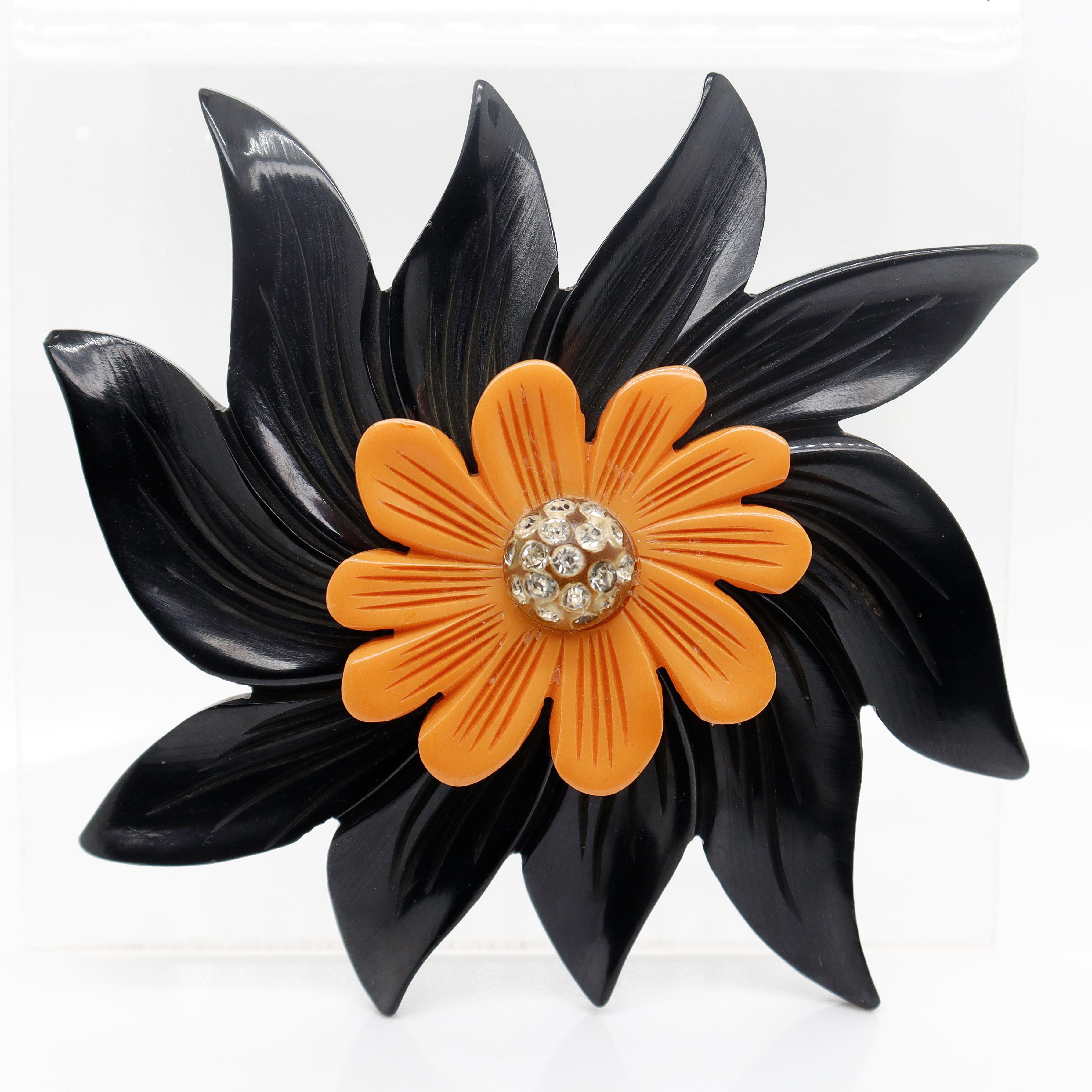 A fine vintage bakelite brooch or pin.

In the form of a flower with black and orange bakelite petals and a convex domed center with pave set rhinestones.

Simply a wonderful vintage brooch!

Date:
20th Century

Overall Condition:
It is in overall