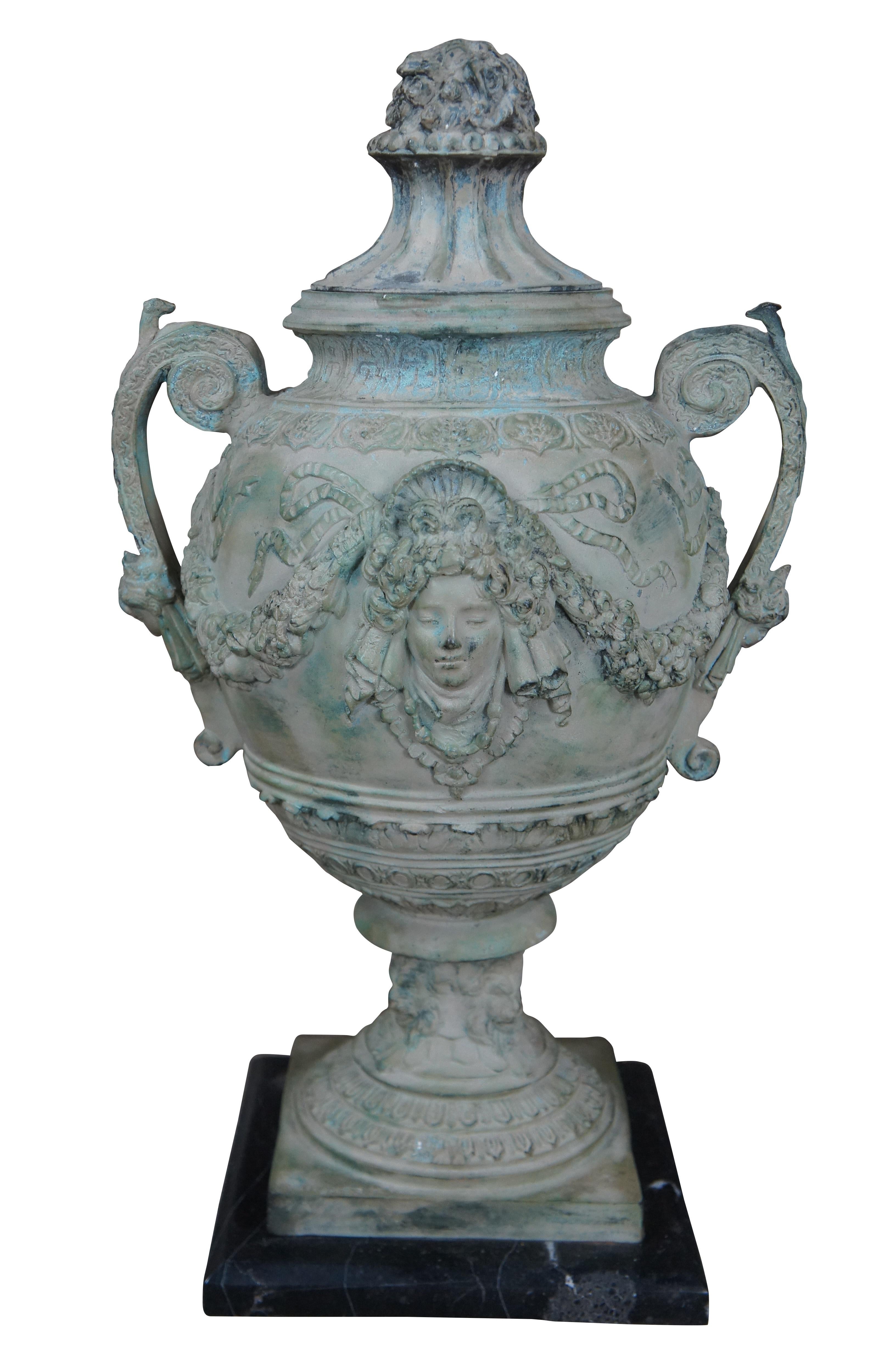 Pair of Neoclassical style patinated verdigris bronze covered urns on stands. Beautifully designed with figures, floral swags, and lions heads around the base. Marked A. Moreau. Each urn is mounted to a black and white veined marble plinth. Circa