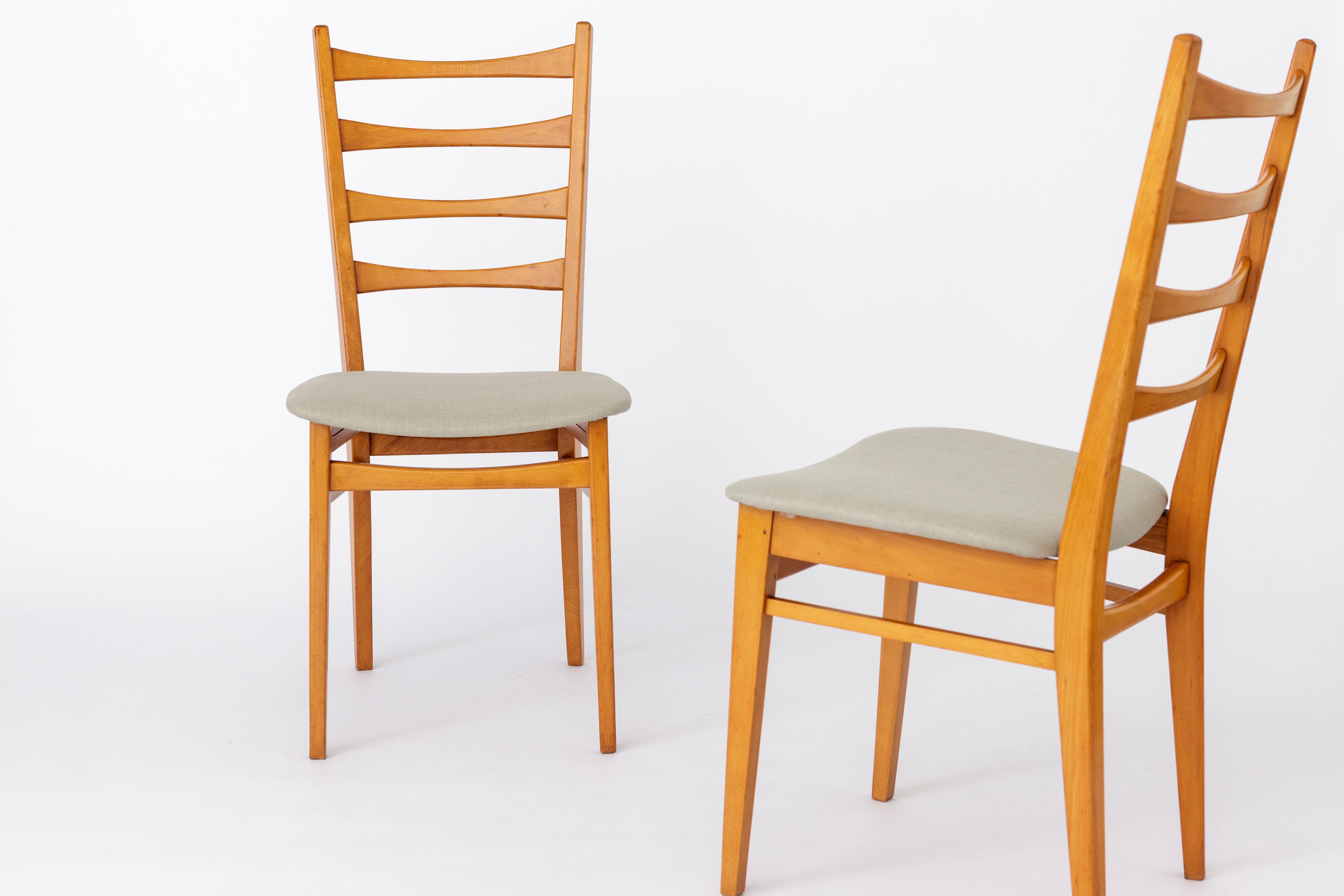 Pair of vintage dining chairs from the 1960s. 
German origin. Unknown manufacturer. 
Displayed price is for a pair. 

Good vintage condition. 
Sturdy beech wood frame, refurbished and oiled. 
Reupholstered seat covers. 
Further details on request. 