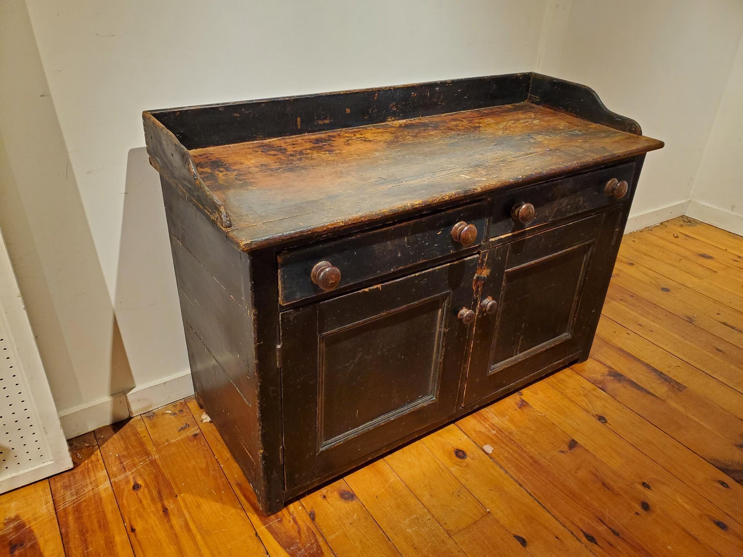 Original worn black paint and more worn table top, with original wooden knobs and a recessed shelf inside make this piece just about perfect