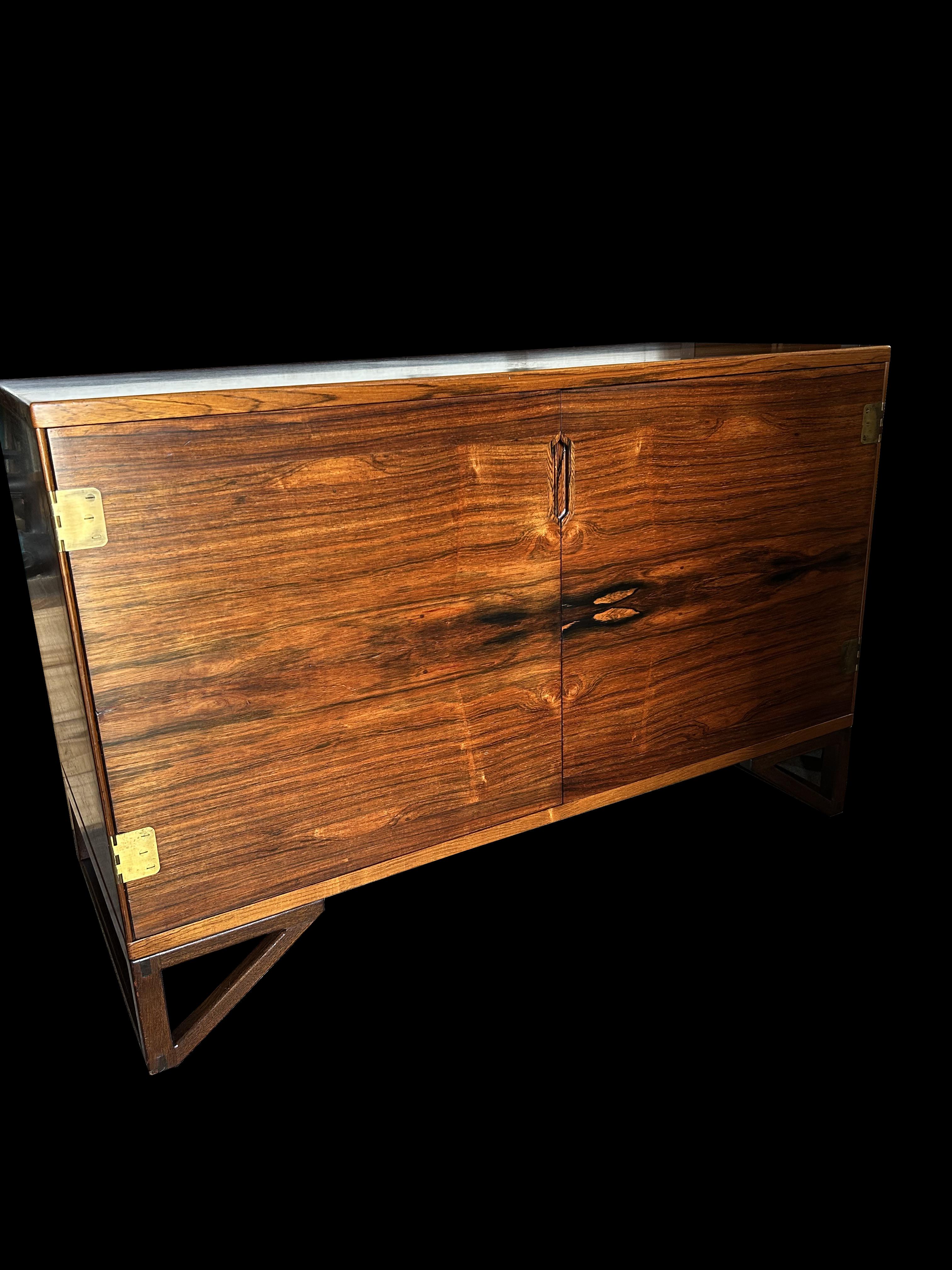 This is a beautiful example of this very stylish cabinet by Sven Lankilde for his own company, Lankilde Mobler.
This one is in Santos Rosewood or Machaerium Scleroxylon, a species not on the Cites list of endangered species, so as well as being easy