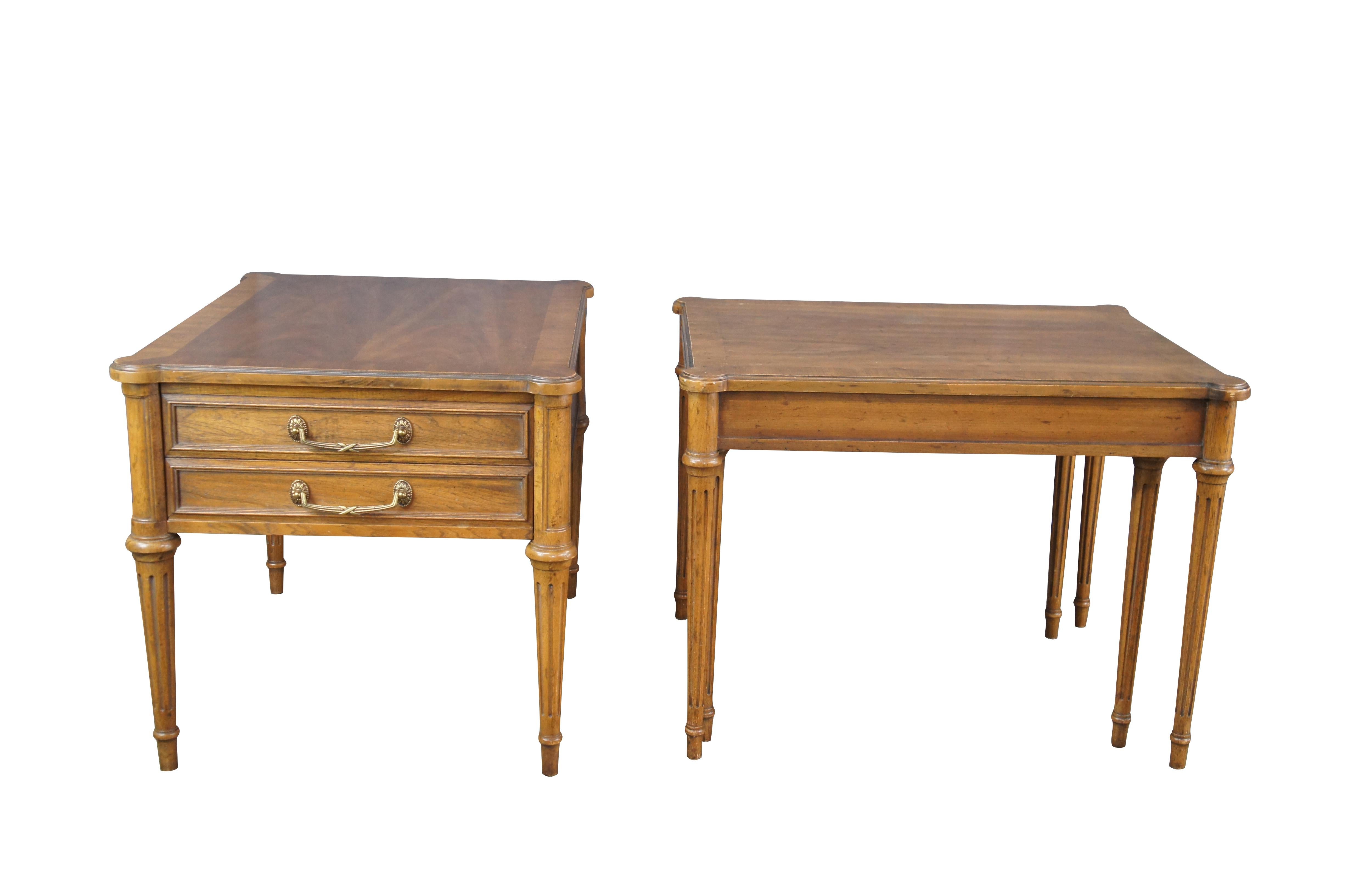 2 mid century French Provincial / Louis XVI style side tables by Drexel Heritage, circa 1968. Features a rectangular form made from walnut with matchbook crossbanded tops. One of the tables has a large dovetailed drawer with neoclassical brass