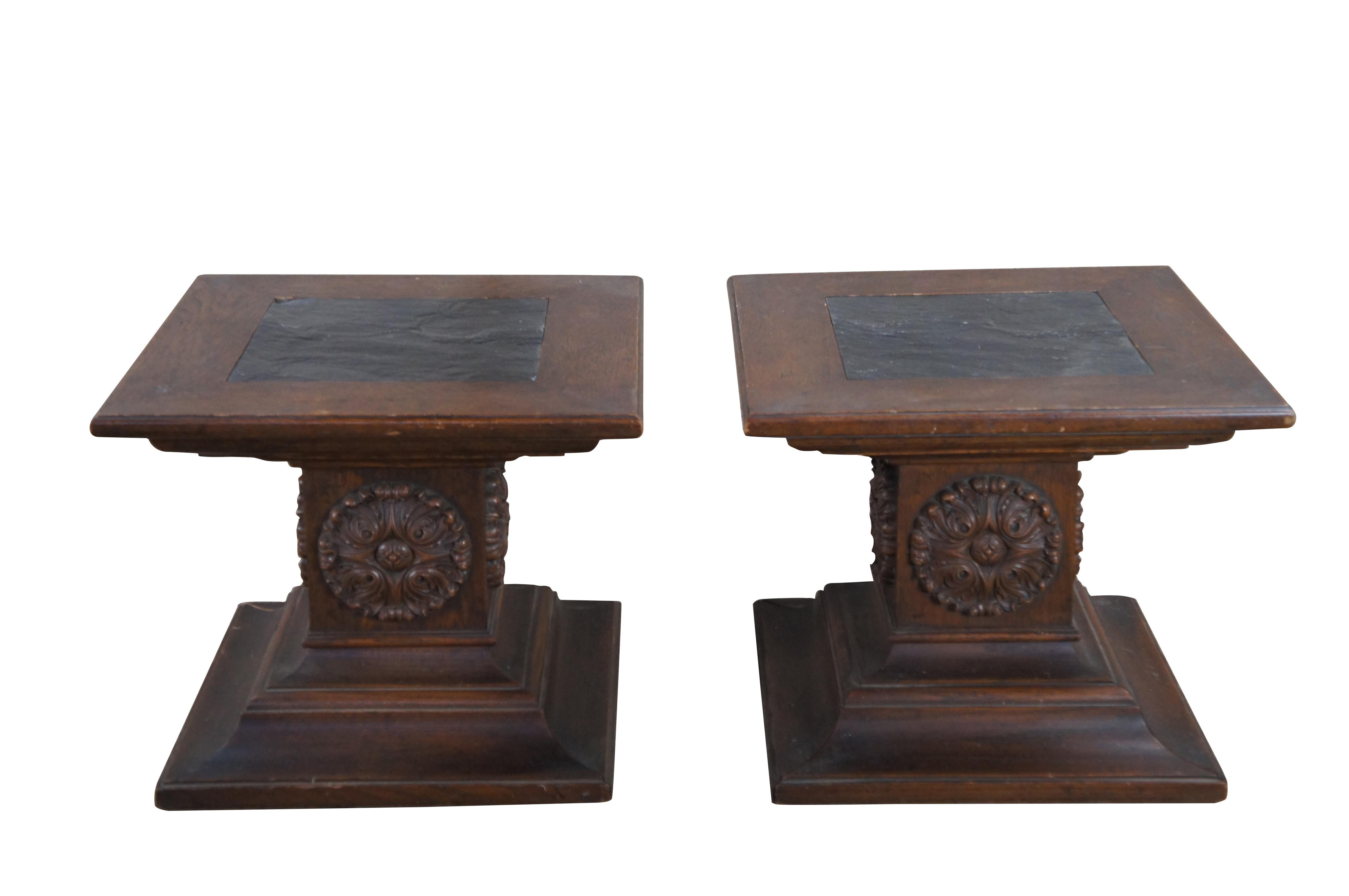Pair of 1960s Drexel Grand Tour pedestal side tables. Made from oak with inset slate top over a central column with round carved medallion and stepped plinth base.  Marked along underside Heritage Grand Tour, 23-507-43.  Great for use as end tables,