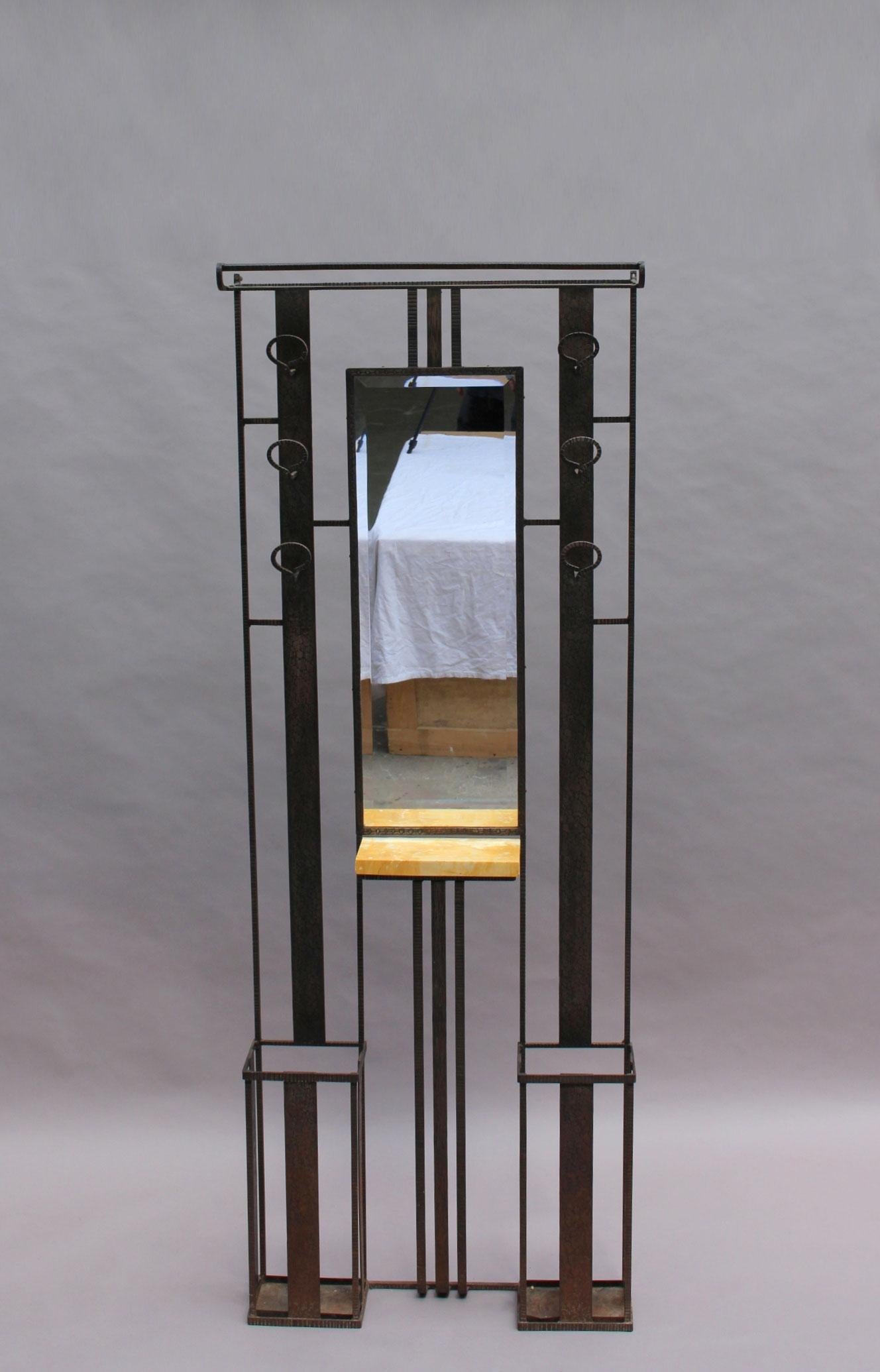 A fine French Art Deco wrought iron coat rack with an umbrella and hat stand, a beveled mirror and a small marble shelf.