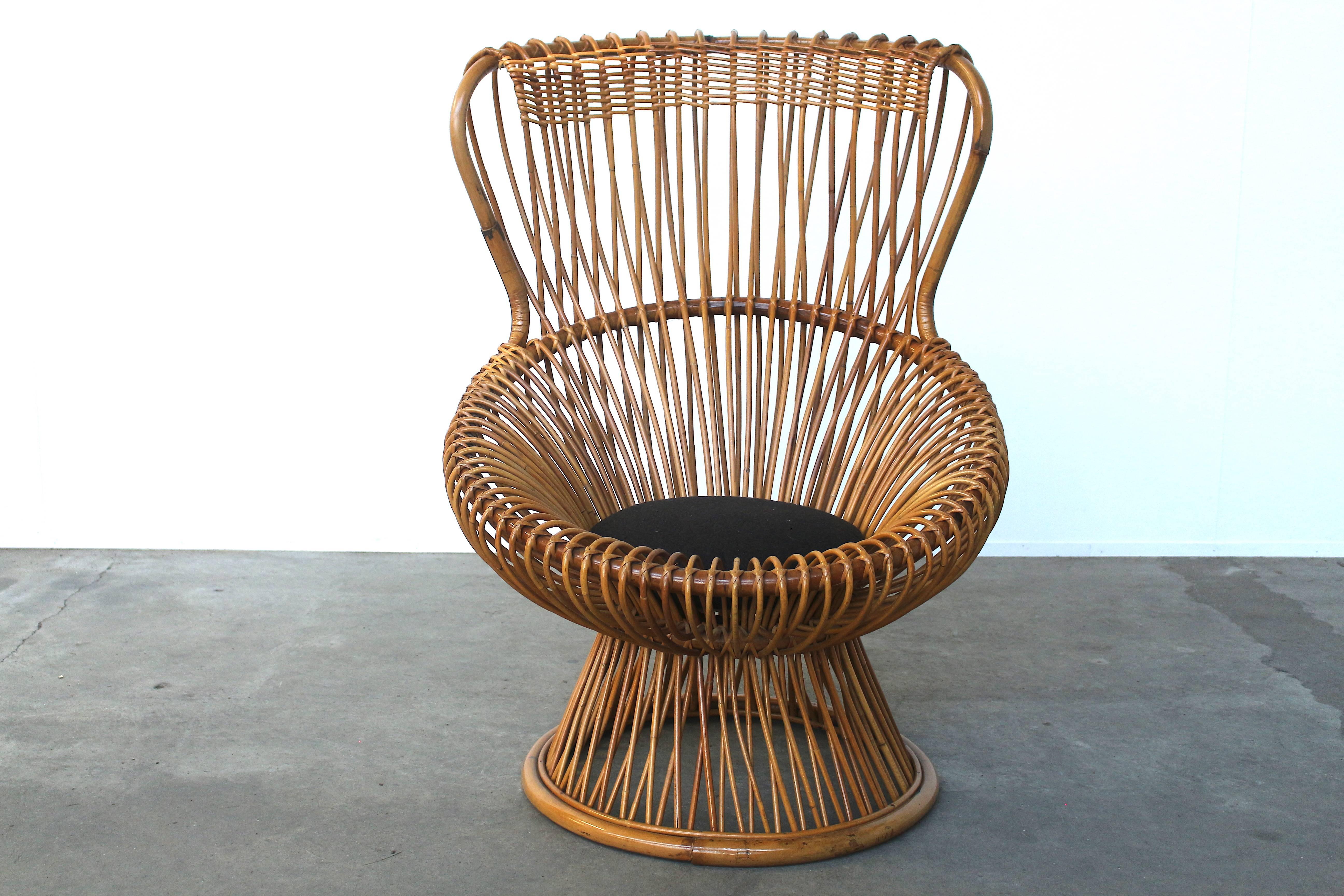 Beautiful rattan chair by Franco Albini, manufactured by Bonacina. All the rattan is in absolutely wonderful condition, no flaws or damages whatsoever. It is also professionally treated against the weather, so is suitable for outdoor use. Comes with