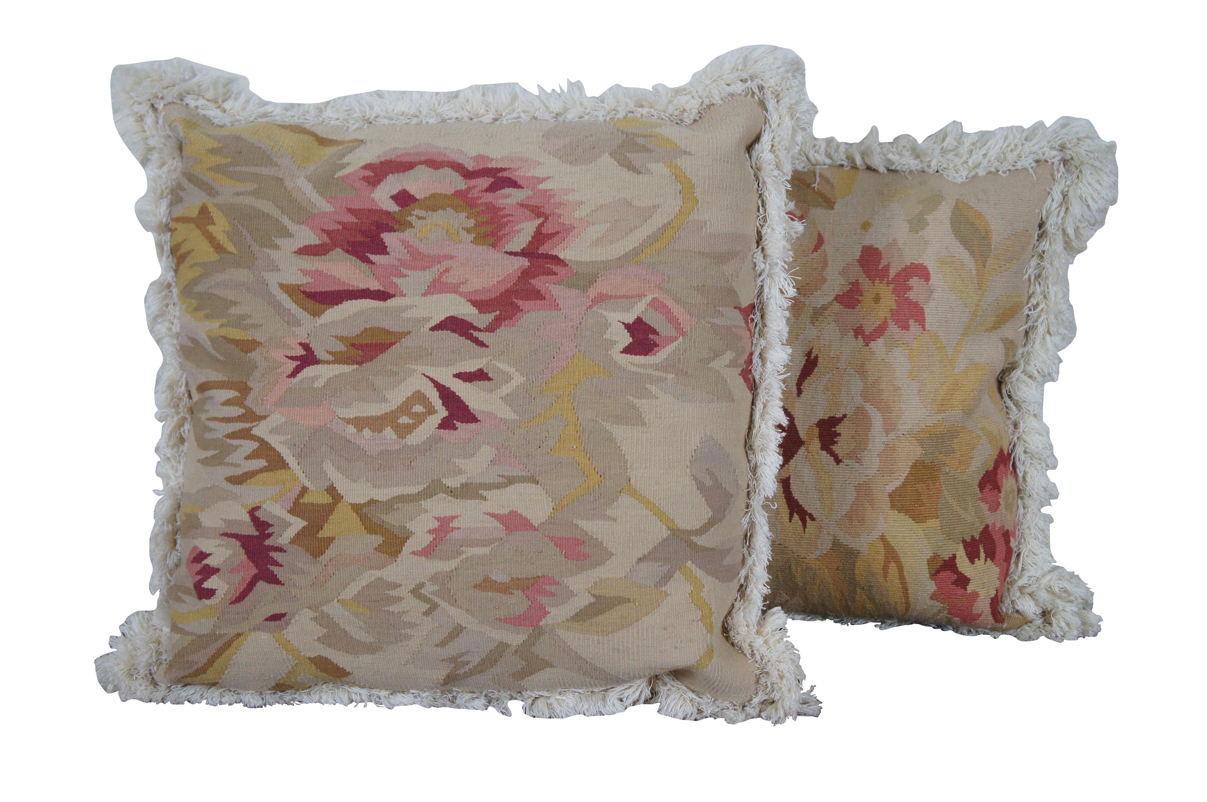 Pair of French Aubusson style throw pillows featuring beige and pink roses on the front with beige / cream velour backs and cream fringe; zipper closure, polyester fiber filled.