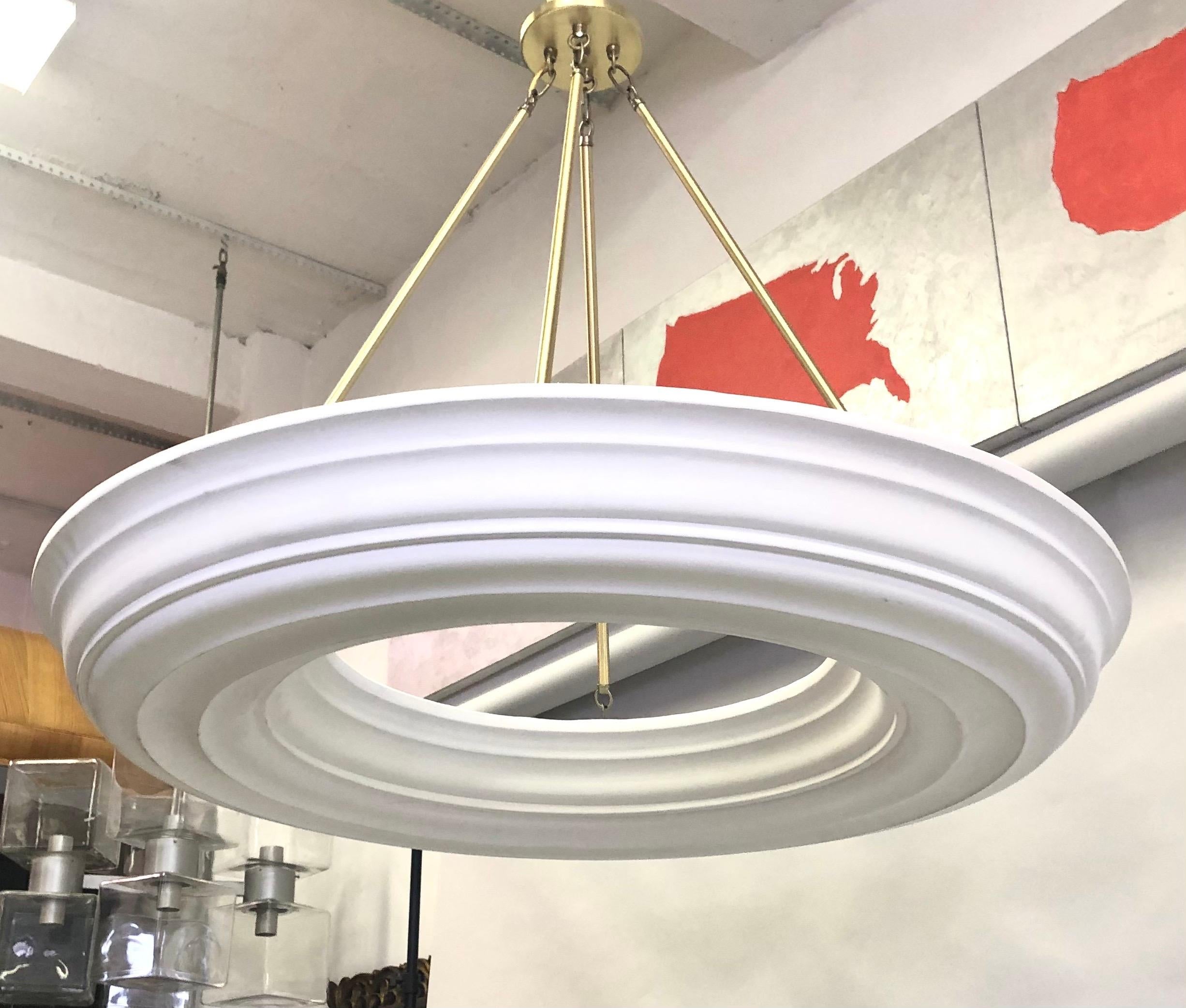 French Mid-Century Modern neoclassical plaster chandelier in the style of Serge Roche. The plaster disc has an open center and is suspended from 4 brass rods and canopy. The brass mounting hardware is adaptable to any height including flush mount