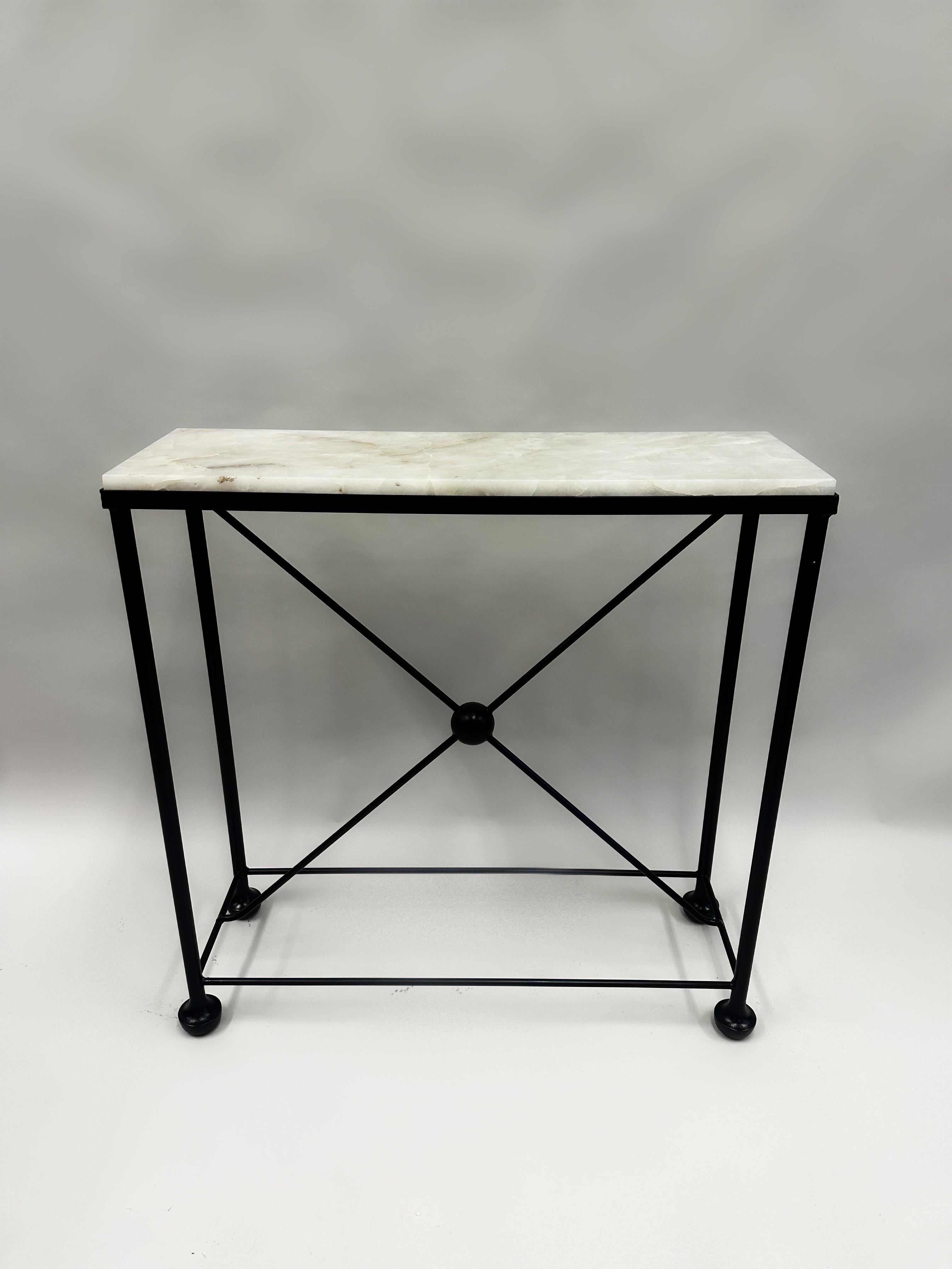 A rare and elegant pair of French mid-century Consoles in the Modern Neoclassical Spirit and composed of patinated wrought iron bases supporting solid slabs of pure rock crystal. Each console is priced and sold individually and reflect the style of