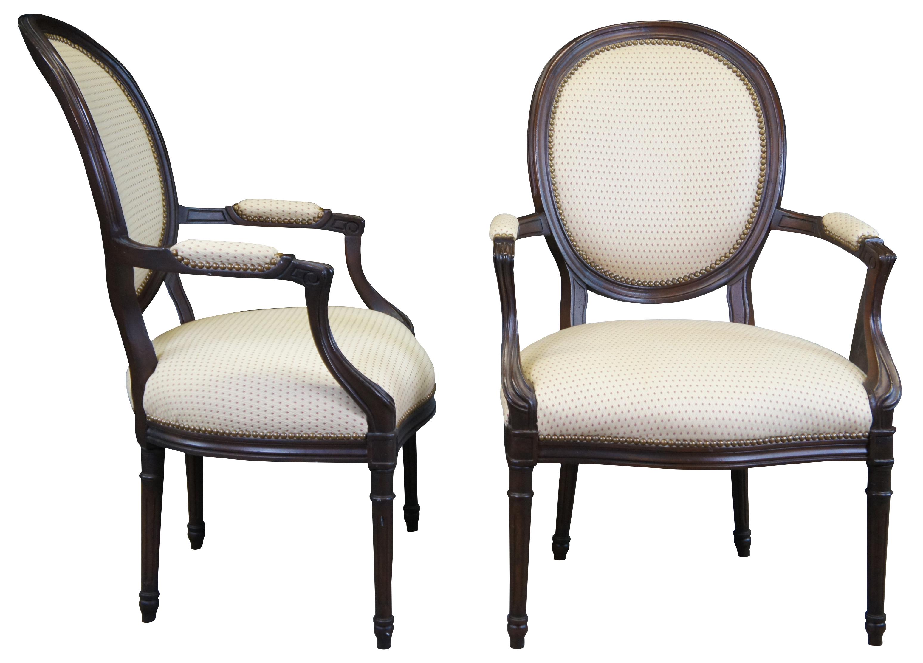 A lovely Neoclassical Revival George III style open arm chair. Features a balloon back, chanelled scrolled padded arms, serpentine seat rail and tapered fluted legs. Finished with brass nailhead trim. A noticeable difference between this chair and