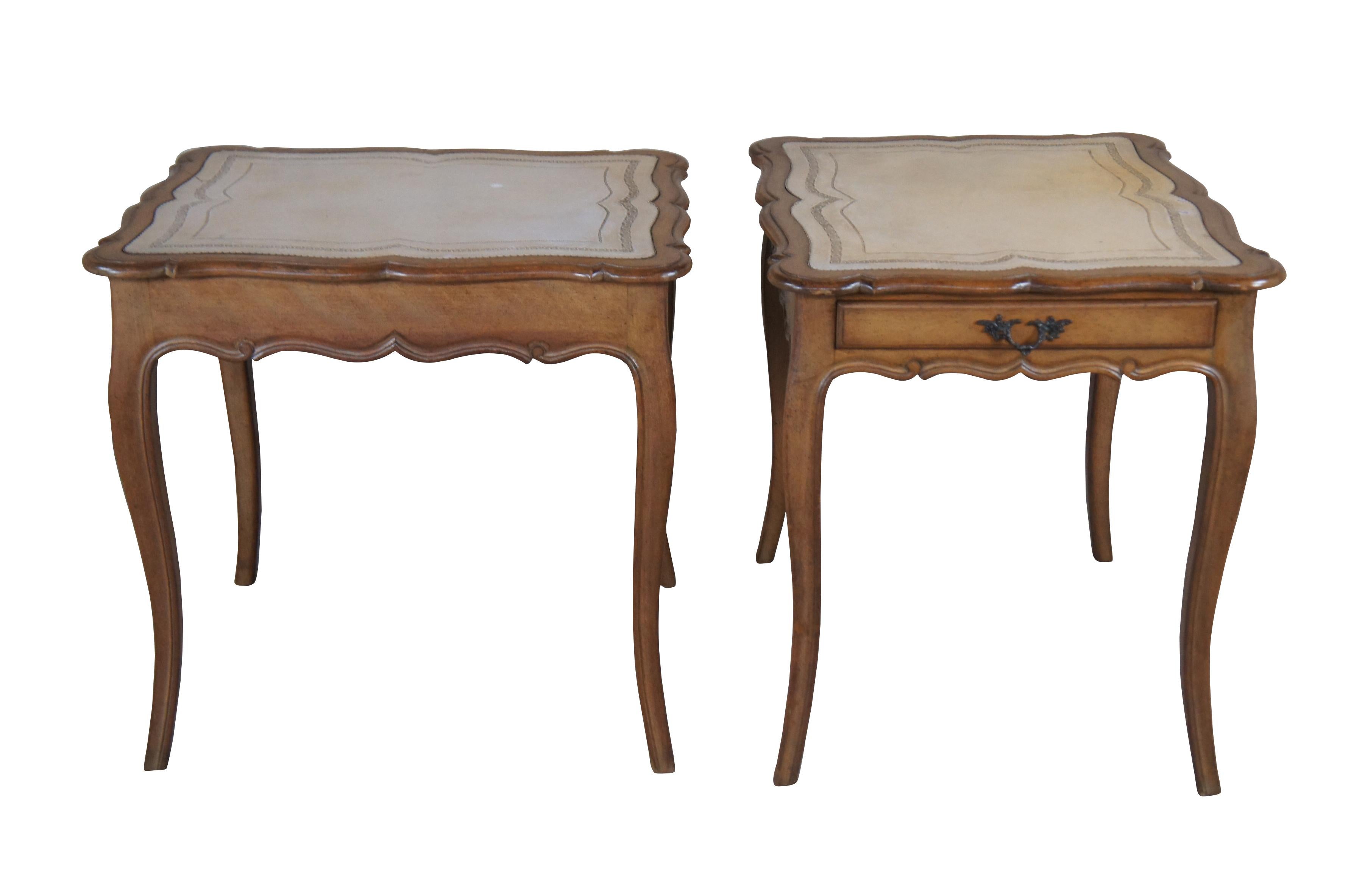 Two vintage French Provincial / Louis XV style side accent tables, circa 1960s.  Made of walnut featuring serpentine form with inlaid tooled leather top, slender dovetailed storage drawer and cabriole legs.

Dimensions:
24