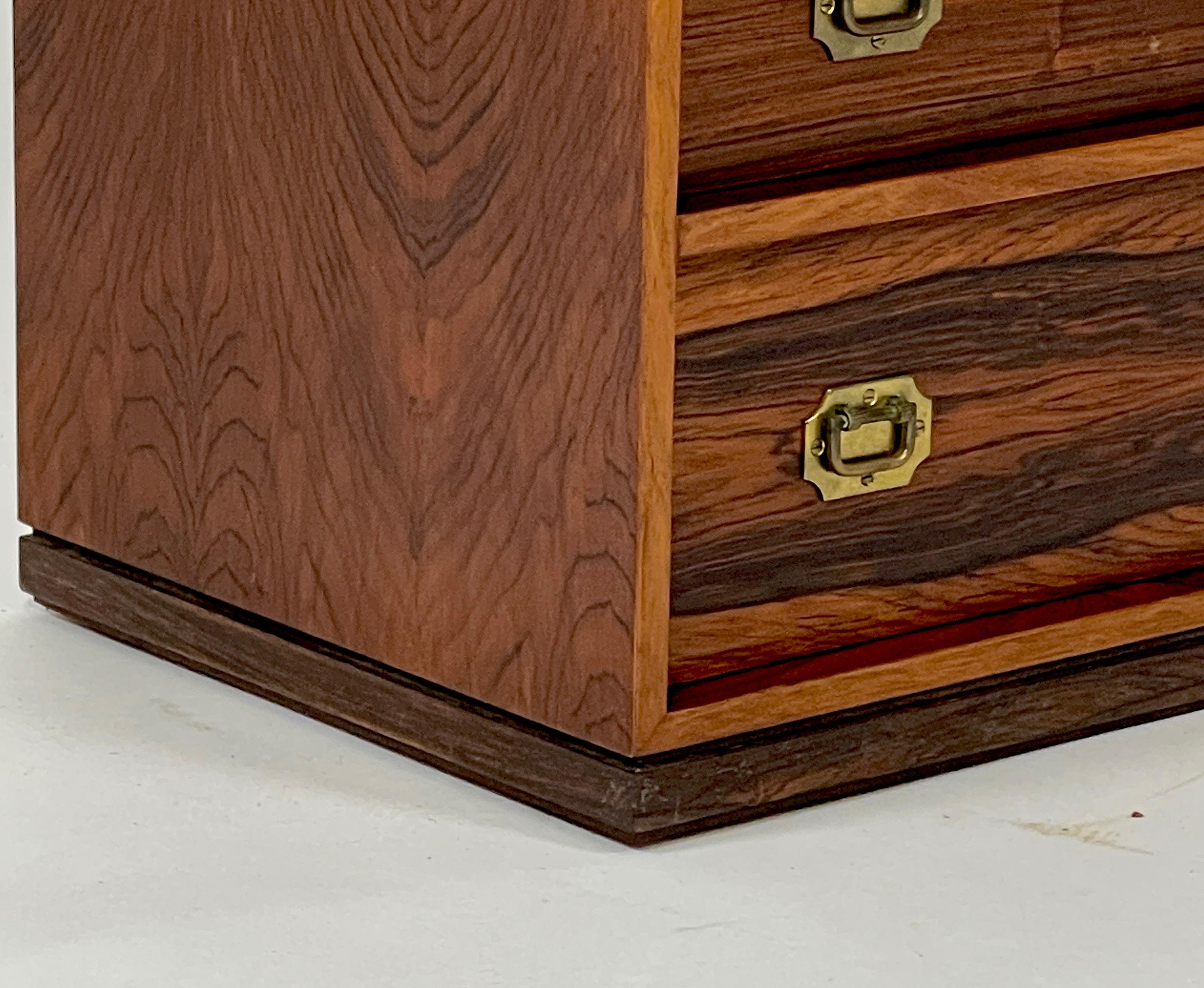 A beautiful petite rosewood campaign style jewelry chest designed by Henning Korch for Silkeborge Mobelfabrik. This particular piece has often been misattributed to Ole Wanscher in the past, but is actually by Henning Korch. The five drawers are