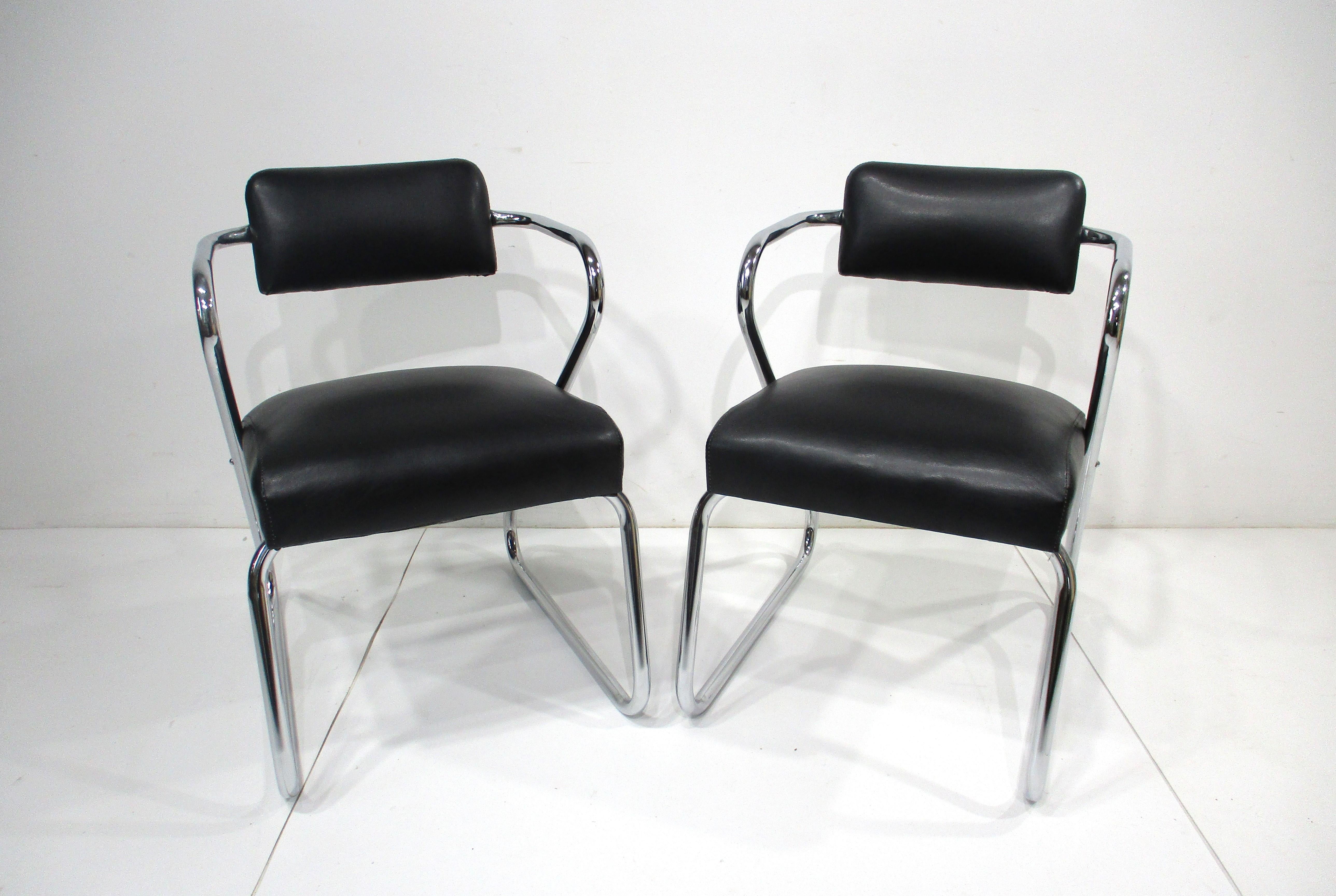 A set of two sculptural chromed framed sitting chairs in the design manner of Gilbert Rohde's Z chairs . Upholstered in a satin black soft and smooth leatherette fabric which makes them very comfortable for long periods . Manufactured by Royal