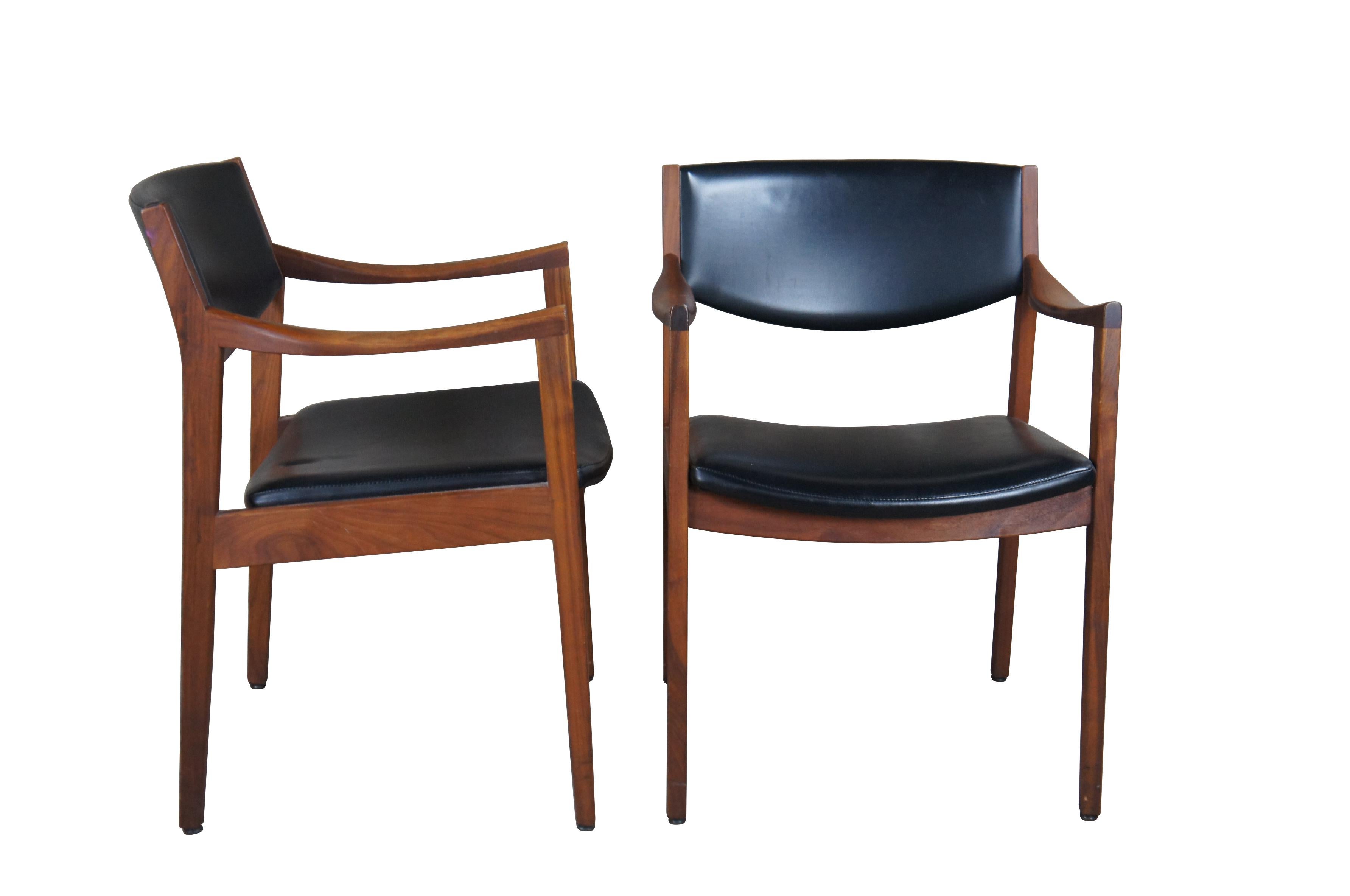 Pair of mid century Gunlocke Jens Risom Style Danish Arm Chairs.  Made of walnut with black leather seat and back.  

The Gunlocke Company's history in Wayland, New York begins in 1902 when William H. Gunlocke and four other wood furniture experts