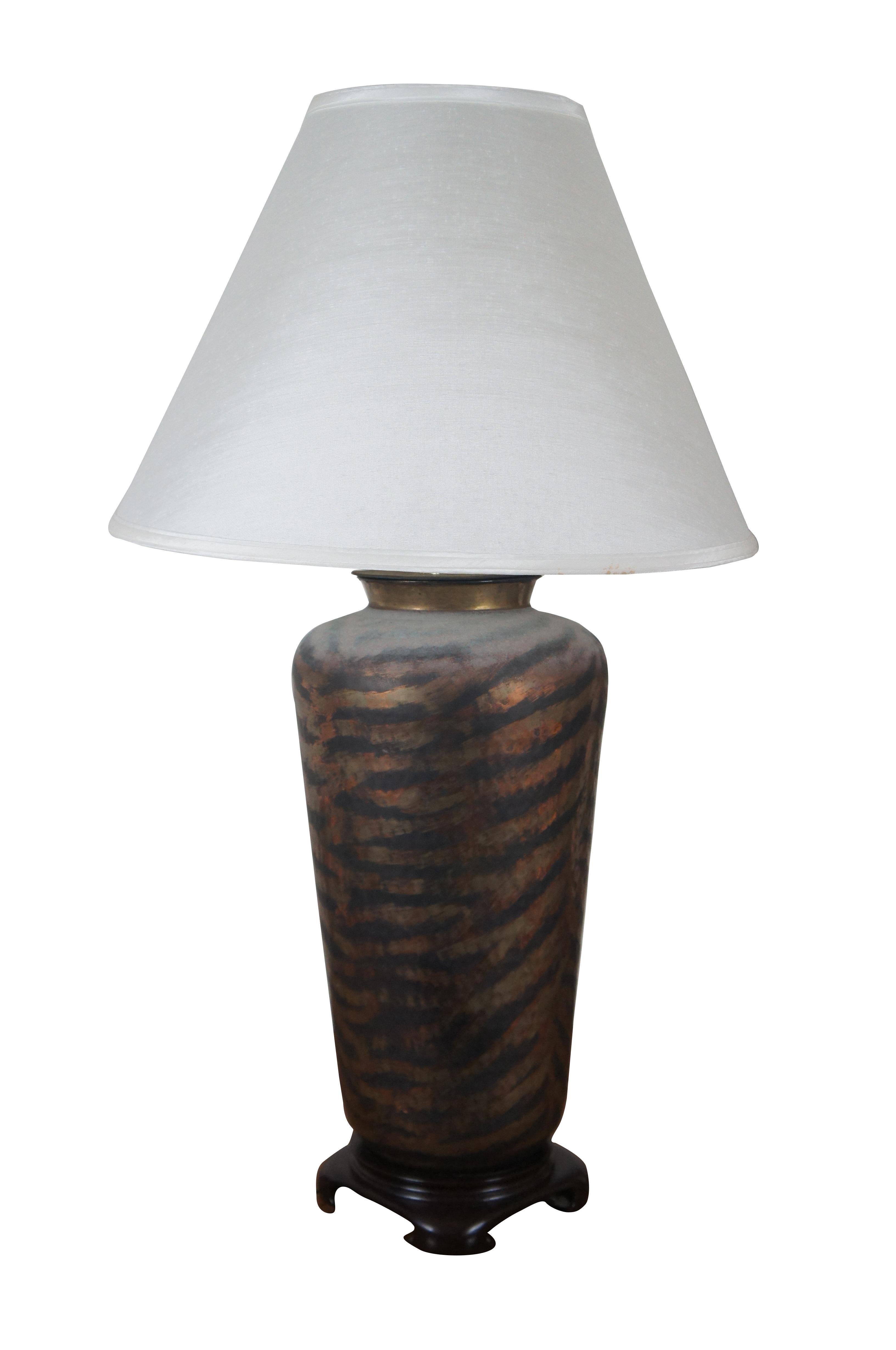 Pair of vintage urn shaped hammered brass / copper table lamps on Chinoiserie style wood bases, painted with a semi-abstract zebra or tiger stripe pattern. Includes white shades.

Dimensions:
9.5” x 23.5” / Shade - 20” x 13” / Total Height –