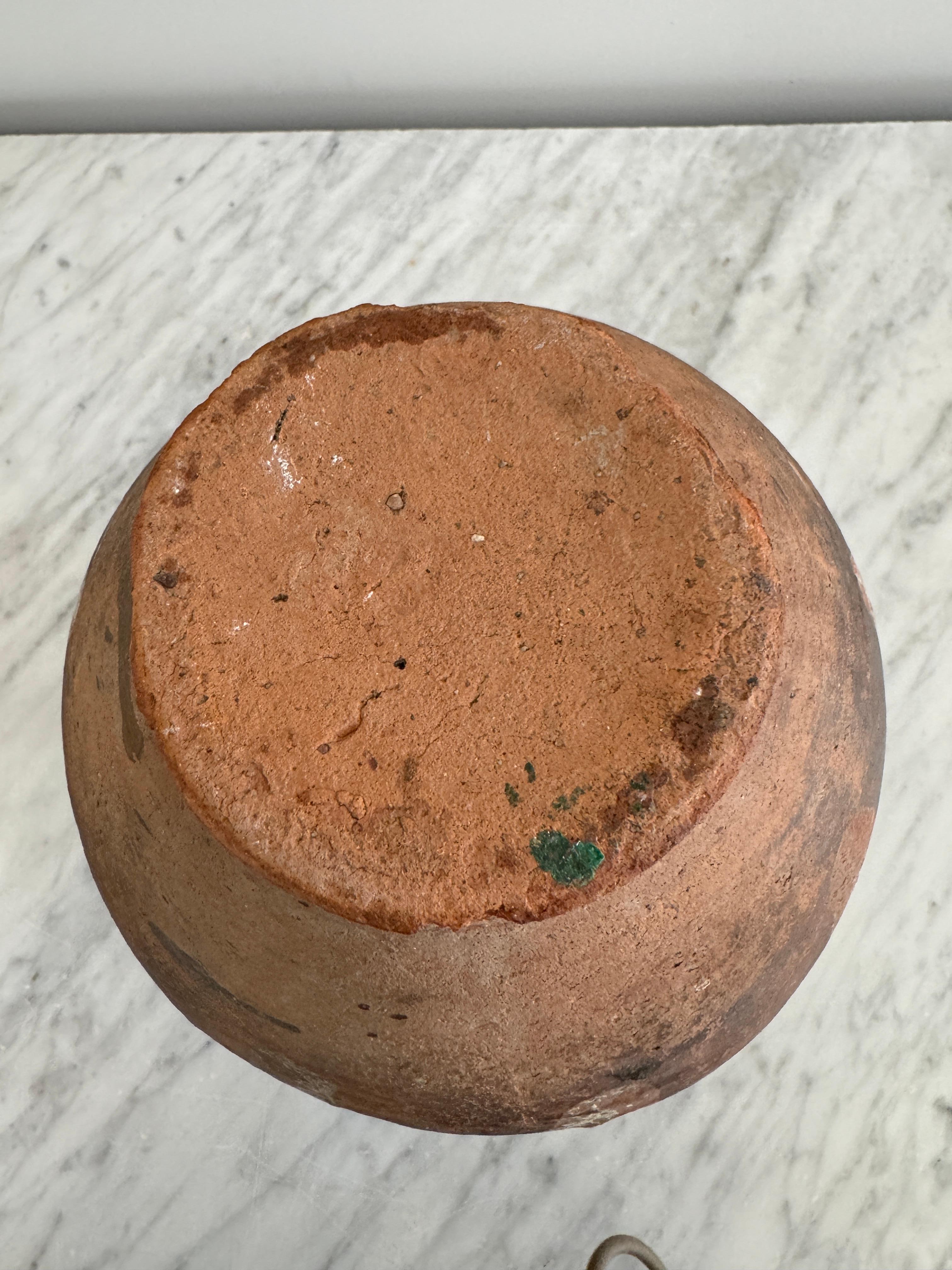 Questa pentola per confetture a due manici a righe, realizzata a mano in Puglia a metà del 1800, è un classico esempio di ceramica rurale italiana. Utilizzato in origine per conservare i cibi sott'olio, riflette lo stile di vita pratico e pieno di