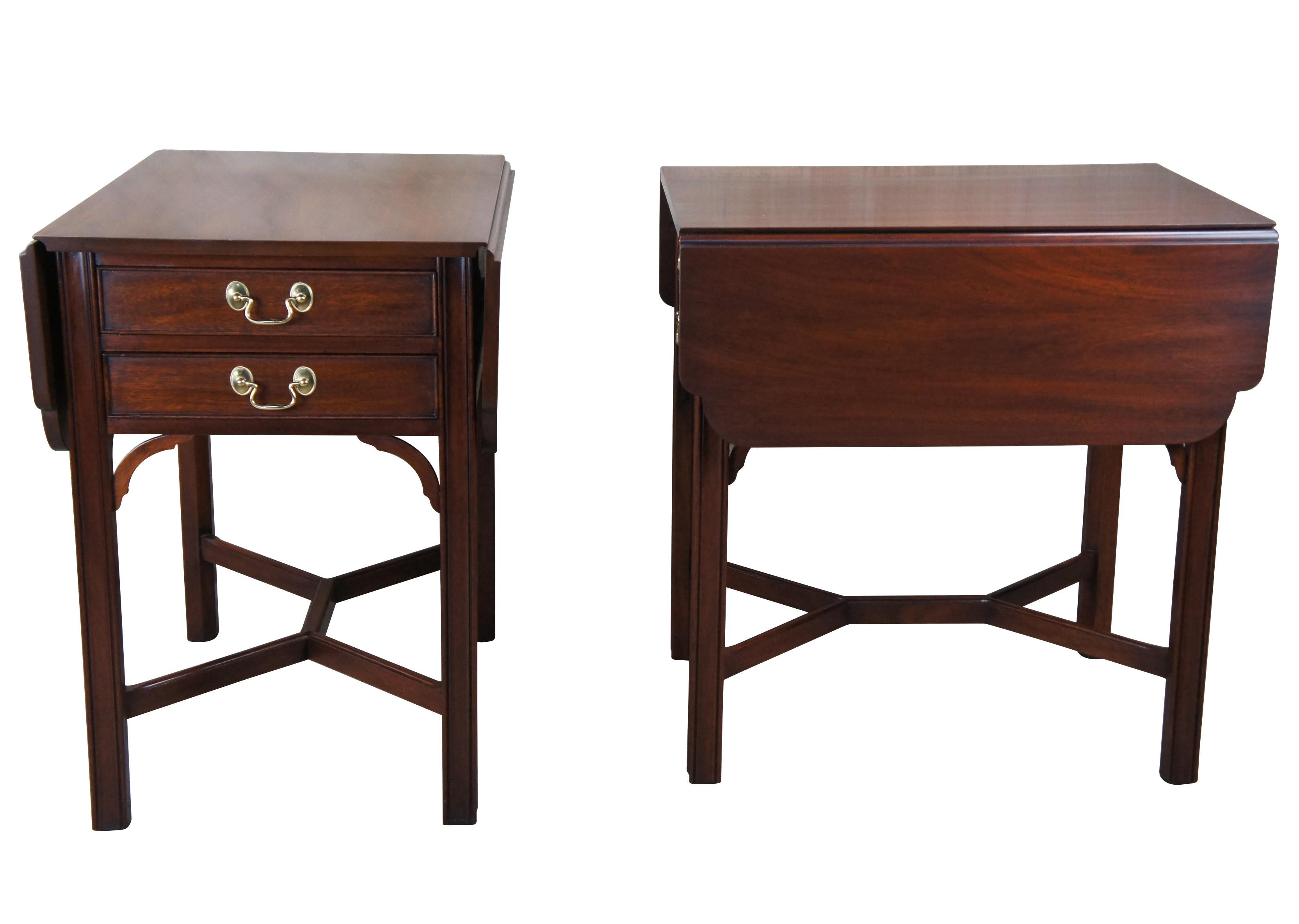 Exceptional pair of English Chippendale style Pembroke tables by Henkel Harris, circa 1988. A rectangular form made from genuine mahogany with drop leaf sides, dovetailed drawers and chamfered legs. The legs are accented by contoured spandrels and